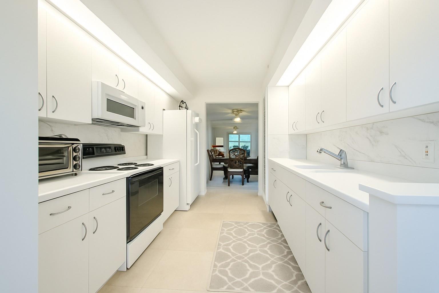 Spacious, sunlit 2-bed, 2-bath corner condo in the sought-after Suffolk II at Century Village! With over 1,500 sq ft, this lakefront unit features a split floorplan, in-unit washer & dryer. The enclosed balcony is perfect for relaxing with water views and stunning sunsets. Well equipped galley kitchen offers plenty of storage. Oversized primary suite with a large walk-in closet and shower. Enjoy maintenance-free living in a vibrant 55+ community with resort-style amenities—clubhouse, pools, golf, tennis, theater, fitness center, restaurant, courtesy bus & more. Basic cable, sewer, water, reserves, roof, 24-hour security, exterior insurance included. No assessments. Prime location near shops, houses of worship, dining, medical offices! 650 credit score, No rentals first 2 years.