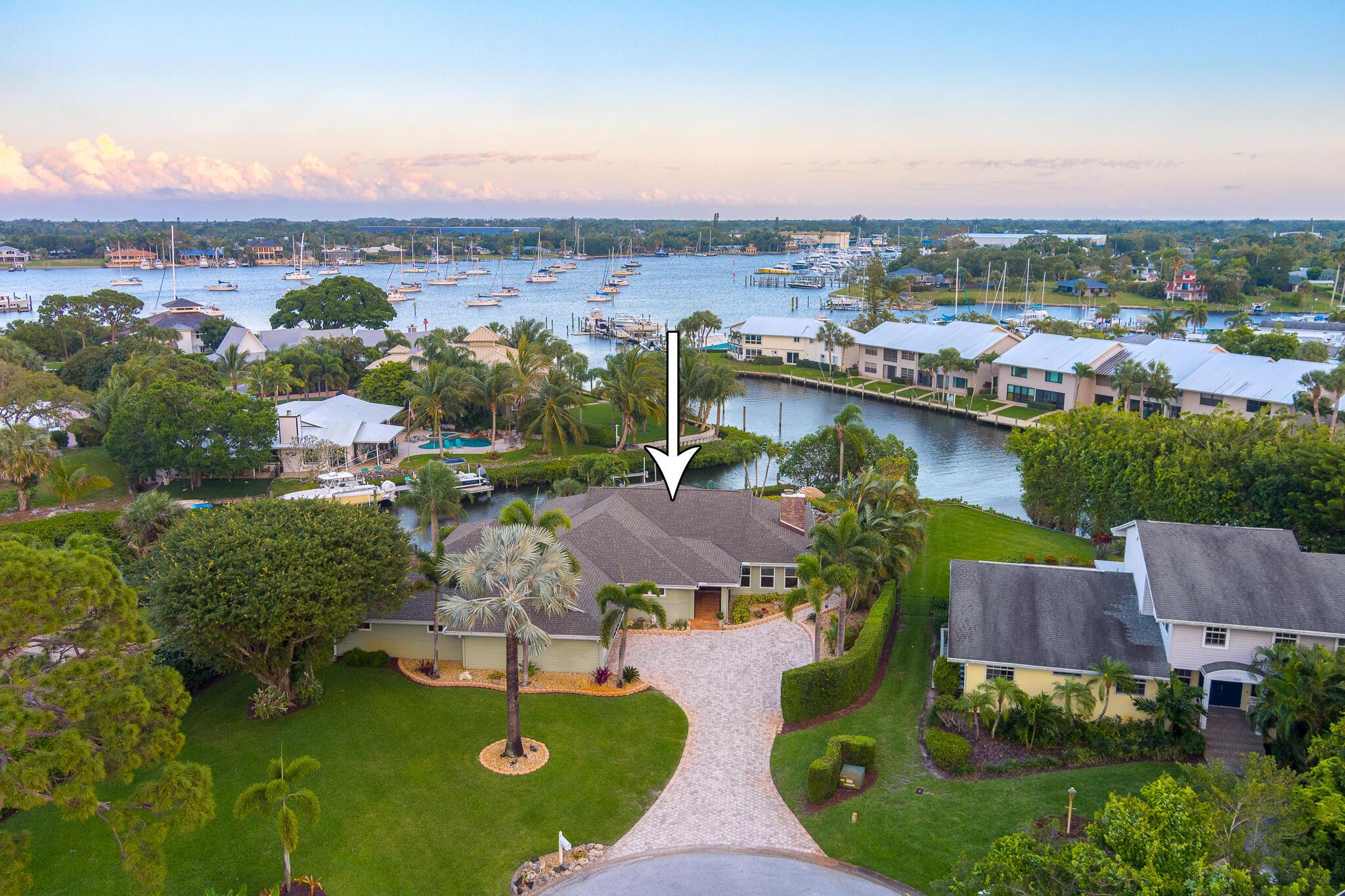 Fully Furnished & Turnkey, Beautiful Waterfront Pool Home, hardwood floors, lush landscaping. Very gently lived in by Snowbirds since 2006 w/approximately 147' water frontage on over .5-acre lot with views of Manatee Pocket. 40' dock w/a Hi-Tide 12,000 lb lift with TEC Remote Control & 4 new pilings added in 2014. Brazilian Ipe' wood Dock equipped w/water, electricity, oversized mounted dock box, attached cleaning table. Easy, quick access to Manatee Pocket, no bridges to St Lucie Inlet. Have lunch by boat at a waterfront restaurant in the Pocket, then head to the Sandbar for all day fun in the sun, only 10-15 minutes by boat. Covered Paver Patio, Summer Kitchen, heated saltwater pool w/natural rock waterfall on the waterfront & Impact Glass windows. Clubhouse, Marina, Pickleball, 2 Pools