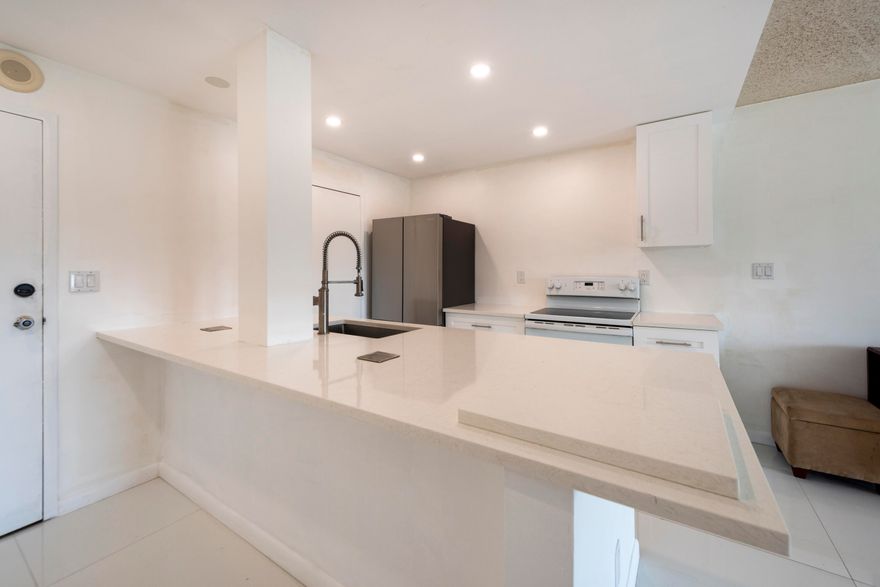 East facing open plan unit with renovated kitchen offering Quartz Counters, white appliances and Shaker Cabinetry, tile and laminate flooring, Jack and Jill bath connects both bedrooms, private storage closet, impact windows, secured lobby, video surveillance, a heated community pool, barbecue area, community room, on-site laundry room.  Building is close to shopping, dining, entertainment and parks.