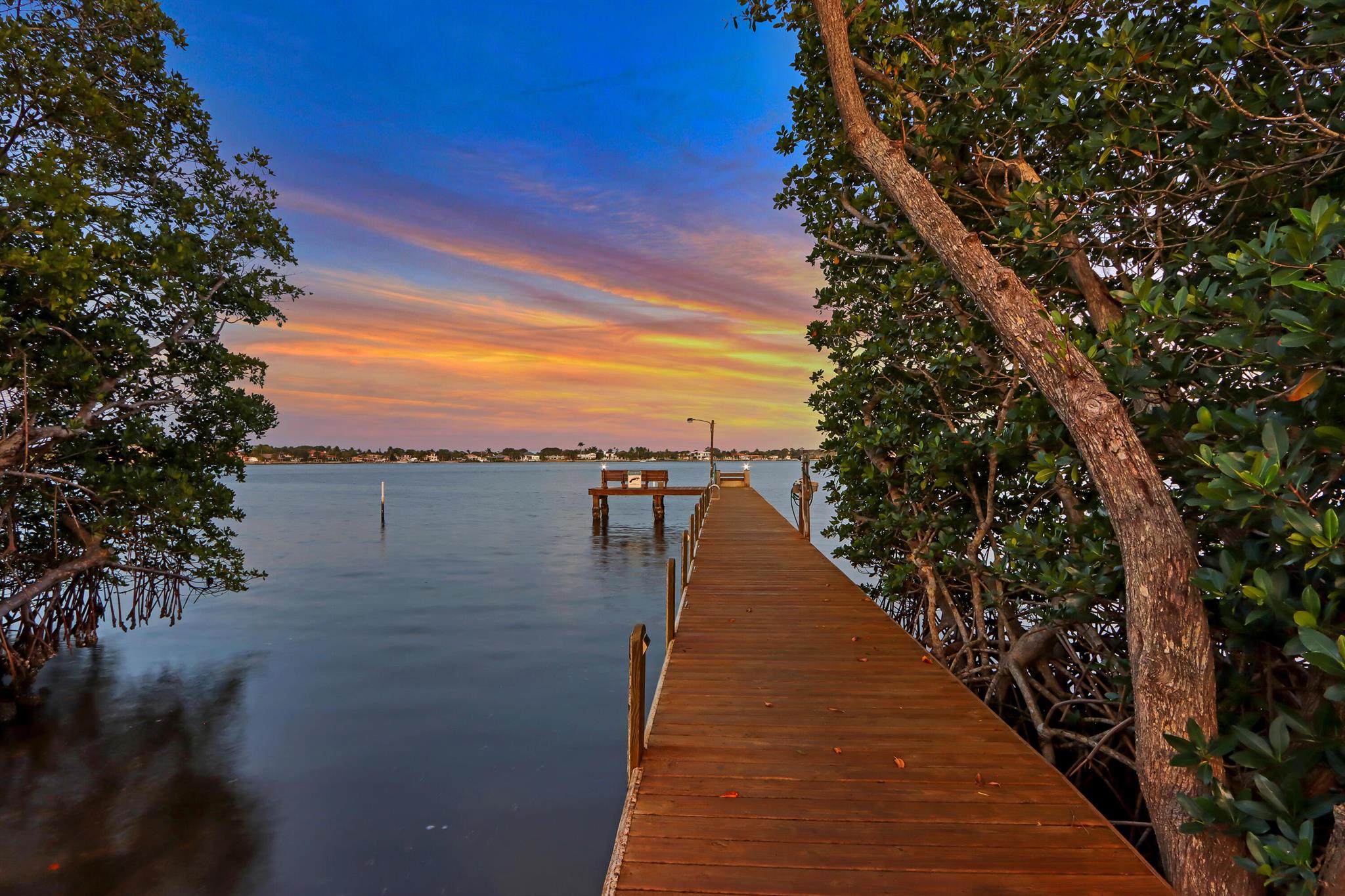 BOAT STORAGE & PRIVATE RAMP - 3 bed, 2 bath w/ IMPACT GLASS, *NEW KITCHEN* on .5 acres in a quiet cul de sac in coveted Eagle's Nest. The living room welcomes w/ oak floors & natural light, then the kitchen (2022) boasts soft close cabinets, drawers, slide-outs, quartz counters w/ marble backsplash an island and ss appliances. Next, the ceilings soar in the spacious family room where a wood-burning fireplace is the centerpiece. The screened lanai is accessed via sliding doors (3 sets) and offers views of your impressive backyard. Back inside 2 guest bedrooms (both w/ walk-in closets) share a full bath w/ tub/shower combo, 2x vanity and cabana door. The main bedroom has 2 walk-in closets, lanai access and Jacuzzi tub. Finished w/ pantry, laundry, 2 Car Garage, 35' boat pad. A-Rated Schools