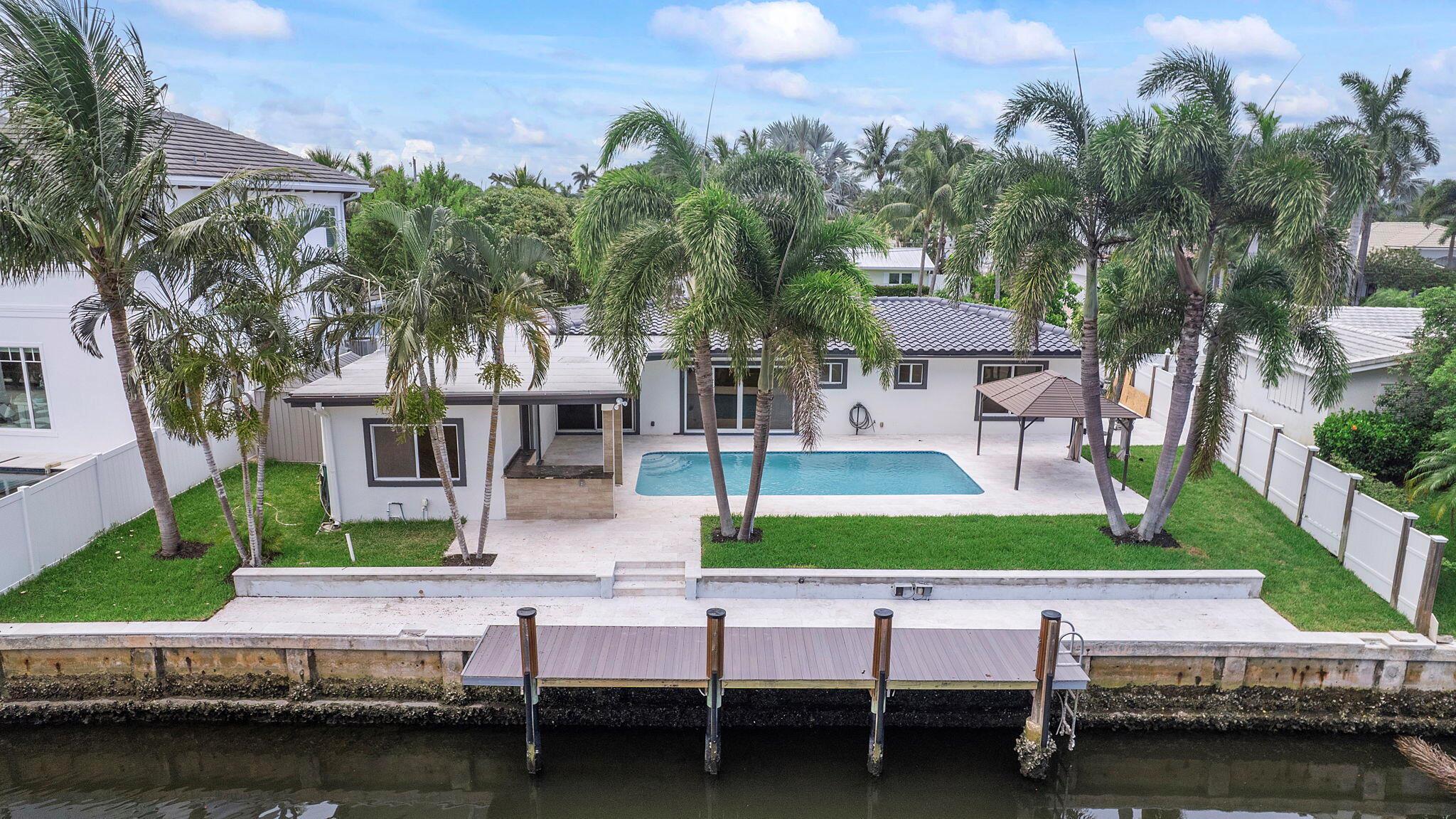 Welcome to a one of a kind, stunning, waterfront, modern tropical oasis. 808 NE 72nd Street is a single family home in desirable non HOA neighborhood of Boca Harbor, east Boca Raton. The home features an 80 ft dock with NO FIXED BRIDGES! Bring your boat/yacht and enjoy waterfront living at its finest. Be the first to occupy this recently updated home featuring the finest in modern appointments. 4 bedroom, 3-bath, garage, modern heated-pool, brand new slip-resistant stone deck, new boat dock, neutral wood style flooring throughout the entire interior of home (no carpet at all!), modern kitchen with stainless steel appliances and quartz countertops, a large dining island, updated bathrooms, open floorpan with split and spacious bedrooms (main master bedroom on