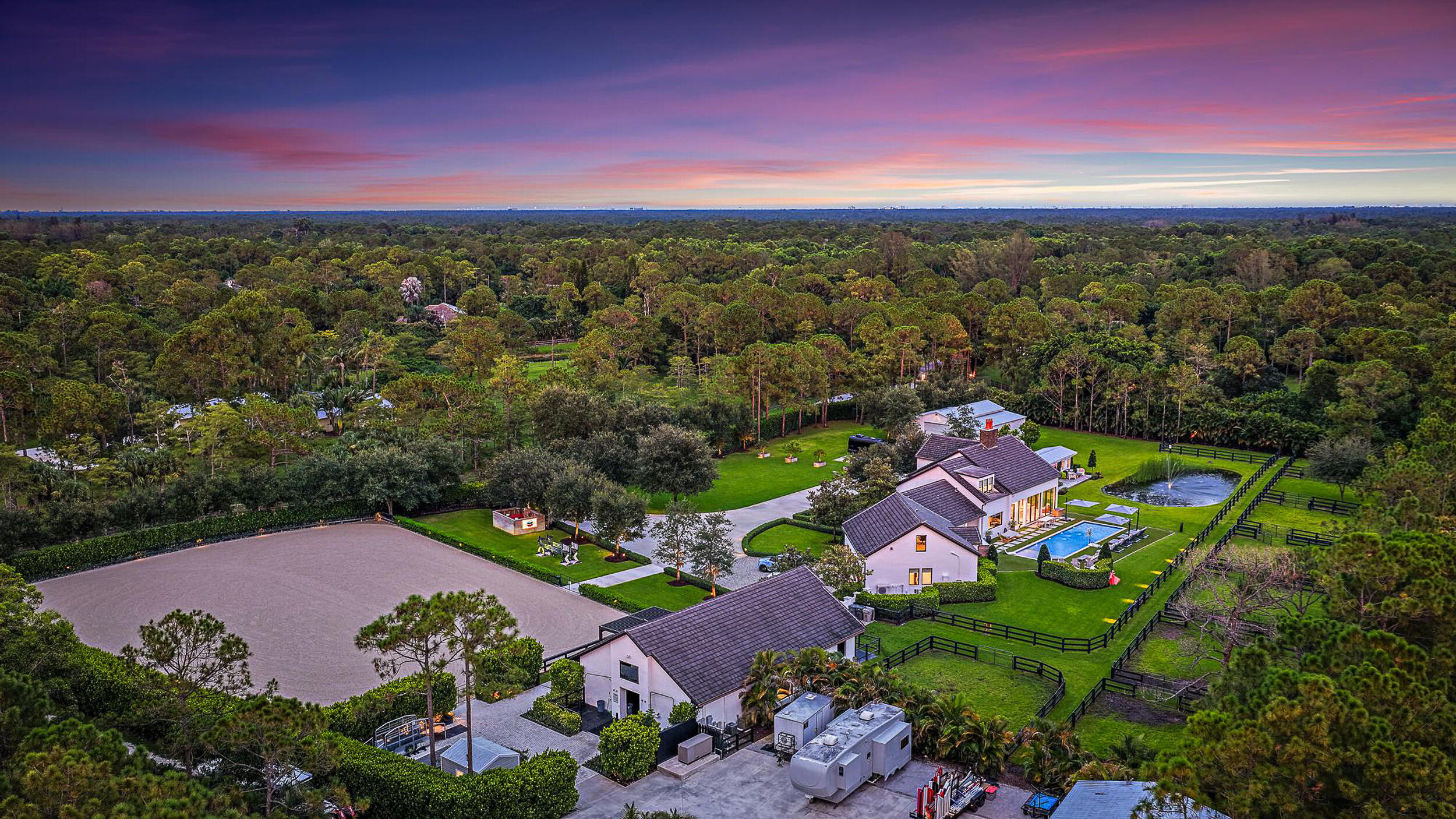 This completely reimagined estate combines timeless charm with modern luxury on 5 private acres in Palm Beach Gardens' coveted equestrian community of Caloosa. Designed as a full retreat, it offers open, sun-filled living spaces and resort-quality amenities inside and out.Walls of windows frame the flowing layout, connecting the designer kitchen, dining area, and inviting living spaces. The primary suite features a morning bar, custom wardrobe closets, and a spa-style bath. Multiple guest suites and a luxury in-home cinema provide space for everyone to unwind.A fully automated Control4 smart home system with Josh AI manages lighting, climate, entertainment, and security--delivering convenience to match the estate's beauty.The backyard is an entertainer's dream with a lap pool