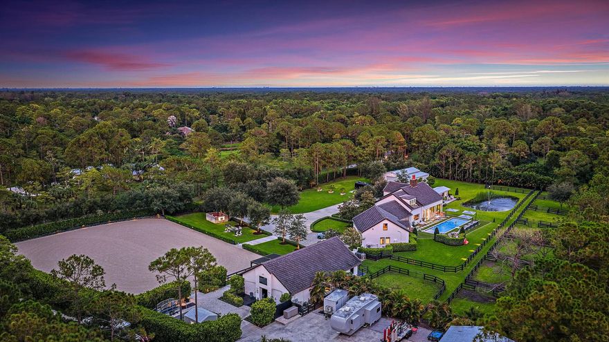 This completely reimagined estate combines timeless charm with modern luxury on 5 private acres in Palm Beach Gardens' coveted equestrian community of Caloosa. Designed as a full retreat, it offers open, sun-filled living spaces and resort quality amenities inside and out.Walls of windows frame the flowing layout, connecting the designer kitchen, dining area, and inviting living spaces. The primary suite features a morning bar, custom wardrobe closets, and a spa-style bath. Multiple guest suites and a luxury in-home cinema provide space for everyone to unwind.A fully automated Control4 smart home system with Josh AI manages lighting, climate, entertainment, and security, delivering convenience to match the estate's beauty. Every detail has already been thought through - even