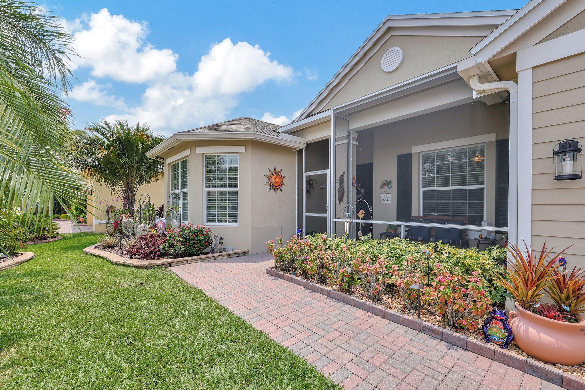 This spacious immaculate snow bird's home is in Bedford Park, which is a quiet family neighborhood, is one block from the clubhouse pool and only 0.7 miles from many activities at Tradition Town Center. Home features include an expansive private water view with spectacular sunsets, 3 bedrooms, 1 flex room, 2 baths, an oversized master suite, a super kitchen, dinette, a great room, dining room, an extended lanai and front porch both screened-in, a paver-walk from the front to the back paver-patio, exquisite landscaping with lighting, all hurricane impact windows, dry bar, tile and luxury lifetime flooring, custom window treatments, Nest t-stat, alarm system, keyless entry, hi-hat lighting, crown molding, rounded wall corners, single handed f