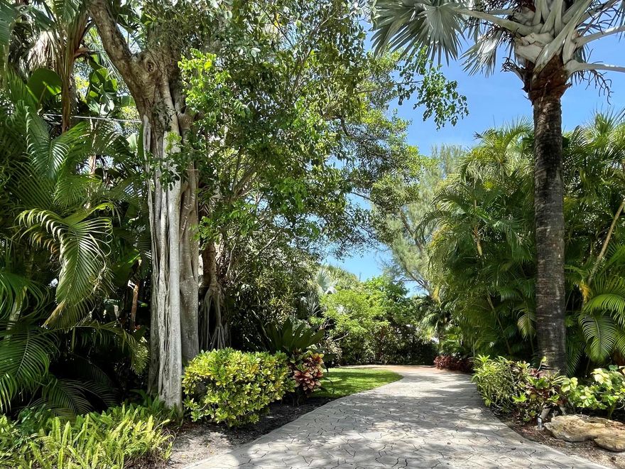 Waterfront charmer offers a dock with lift in a choice location on Hypoluxo Island between Palm Beach and Manalapan. The spacious 5,776 SF custom-built house on a lushly landscaped 23,000+ SF lot features high-end materials, a water view, open concept floor plan, vaulted ceilings, impact windows and sliders, wine storage for 400+ bottles, large screened porch for indoor/outdoor living, plus decks both upstairs and downstairs overlooking the heated pool with spa. The huge, bright main garage accommodates cars, tools, hobbies, and much more, while the separate guest cottage provides sleeping for 4 and another 2-car garage. Relax and enjoy the best of Palm Beach County in this beautiful and secluded compound.