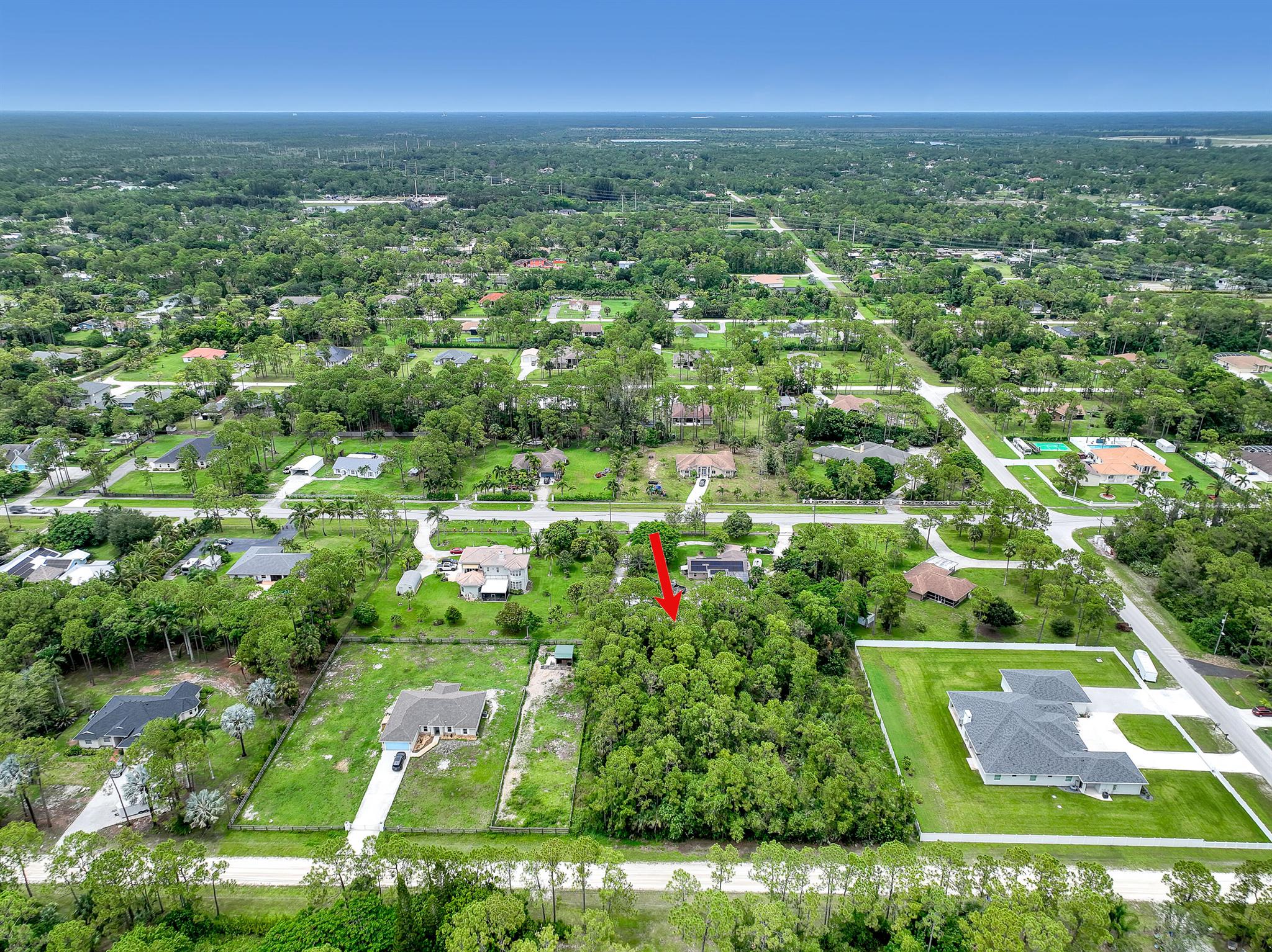 Prime opportunity in The Acreage! This expansive 1.15-acre parcel offers the perfect canvas for your dream estate or investment build. Located just one house from a paved road and surrounded by robust new development, including adjacent high-end construction, the property sits in a rapidly growing area of unincorporated West Palm Beach. Enjoy the privacy and space of country living with the convenience of nearby amenities, schools, and major thoroughfares. No HOA, flexible zoning, and ample room for a custom home, guest house, workshop, or recreational vehicles. Whether you're a builder, investor, or future homeowner, this lot delivers exceptional value in one of Palm Beach County's most active growth corridors.