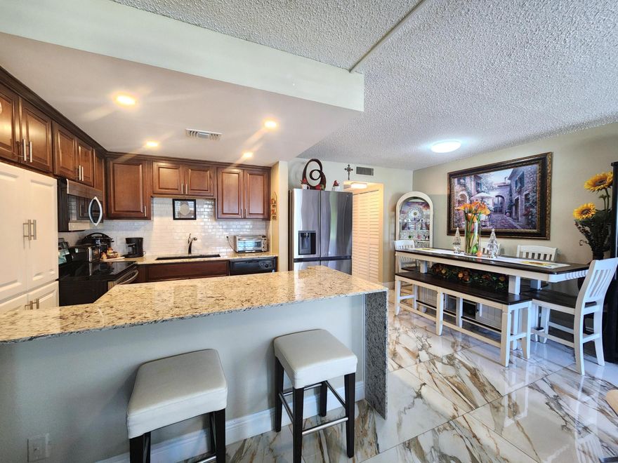 Experience the convenience of first floor in this spacious and completely remodeled residence in popular Century Village.  Interior features open kitchen with raised ceiling, recessed lighting, cascading granite counters, glass backsplash with undercounter lighting, stainless steel appliances and plenty of cabinetry providing plenty of storage.  Other features include gorgeous XLG porcelain flooring, impact glass, updated bathrooms, and enclosed patio delivering an additional bedroom for family and guests.  Exterior opens to sprawling natural preserve.  Century Village is the cat's meow offering the best in amenities with countless walkable pools, tennis courts, & a WORLD RENOWNED clubhouse boasting amazing pool, box office, shows, billiards & more!