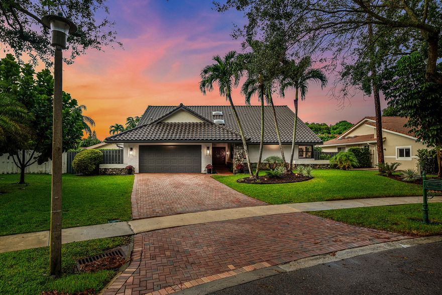Discover a beautifully renovated residence in the highly sought-after Colonnade community, offering 3 bedrooms plus a sunroom that can easily be used as a 4th bedroom, home office, den, or playroom, where quality craftsmanship and thoughtful design are evident throughout. Tucked away on a quiet cul-de-sac along a private road, this home offers privacy and tranquility while remaining conveniently connected to the surrounding neighborhood. Completely renovated with a timeless modern farmhouse aesthetic, this exceptional home blends warmth with clean, contemporary style. The open-concept layout is filled with natural light, enhanced by expansive full impact doors and windows, soaring ceilings, beautiful new porcelain flooring throughout, and custom designer finishes that elevate every space.  The heart of the home is the fully renovated chef's kitchen, featuring premium appliances, custom solid-wood Shaker cabinetry, a spacious pantry with custom shelving, a commercial range hood, dual islands for prep and seating, and a built-in coffee nook with additional cabinetry—ideal for entertaining and everyday living.  The family room features a custom-built entertainment center with shelving and cabinetry, while the bright and airy under-air sunroom/bonus room opens directly to the pool area and beautifully landscaped backyard, creating the perfect retreat.  The fully remodeled bathrooms offer a spa-like retreat with elegant finishes and a calming palette. The luxurious primary suite features an oversized shower with a natural stone surround, Italian marble flooring, an illuminated vanity mirror with a dedicated makeup area, and an expansive walk-in closet.  Recent upgrades provide peace of mind and efficiency, including a new roof (2023), two new Carrier A/C units, new gutters, an updated electrical panel and water heater, impact-resistant windows and doors, motorized Hunter Douglas Silhouette blinds, custom LED lighting and designer fixtures throughout, refinished exterior stucco with fresh paint, and Ring surveillance cameras with outdoor security lighting.  Step outside to your ultimate private outdoor retreat featuring a newly Diamond Brite-finished resurfaced pool with new tile and terrace finishes, a resurfaced marble terrace, new pool pump, a motorized remote-controlled retractable awning, professionally designed tropical landscaping, surrounding landscape lighting, and an outdoor storage shed—perfect for relaxing or entertaining year-round.  Additional functional features include a 2-car garage with shelving, built-in ceiling storage, and an epoxy-coated floor.  Located in one of Boca Raton's most desirable communities, Colonnade, residents enjoy access to Boca Tierra Park, owned by the City of Boca Raton, featuring tennis courts, basketball courts, playgrounds, picnic areas, and scenic green spaces. The neighborhood is known for its tree-lined streets, family-friendly atmosphere, and community events—all with an incredibly low HOA of just $96/month.  Ideally situated just minutes from the beach, Town Center Mall, world-class dining, shopping, and entertainment, this home offers the perfect balance of luxury, comfort, and lifestyle.