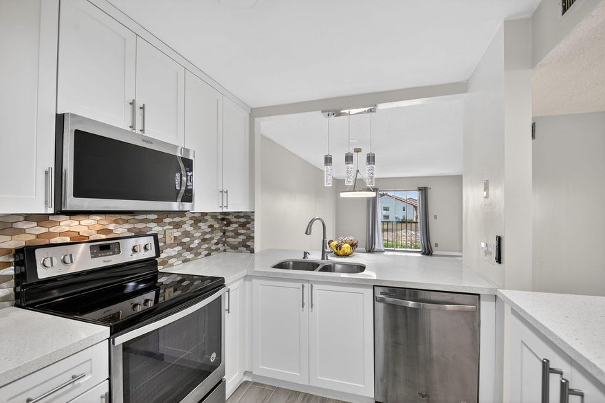 This beautifully maintained 2-bedroom, 2-bath condo offers the perfect blend of comfort, convenience, and modern style. Step inside to a bright, open-concept layout featuring wood-look tile plank flooring throughout and thoughtfully updated finishes. The renovated kitchen shines with stainless steel appliances, sleek cabinetry, and ample counter space -- ideal for both everyday living and entertaining. Additional upgrades include impact windows and a new A/C, providing efficiency, comfort, and peace of mind. The spacious primary suite offers a walk-in closet and private en-suite bath, while the second bedroom is perfect for guests or a home office. Enjoy the added convenience of an in-unit washer and dryer and assigned parking.