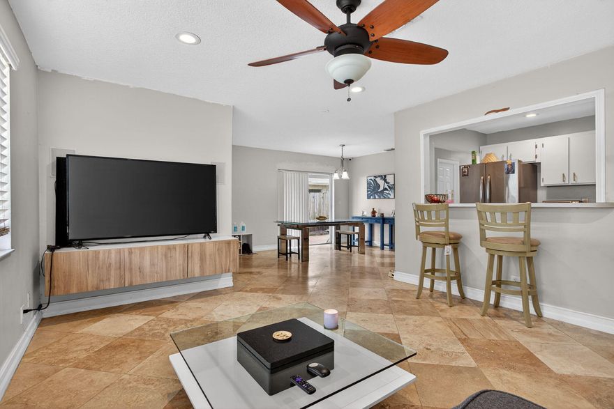 Well-maintained 2-bedroom, 2-bath twinhome located in the heart of Margate. This bright one-story home features an open and functional layout with a spacious kitchen, ample cabinetry, and a large passthrough that connects seamlessly to the living area—ideal for both everyday living and entertaining.  The primary suite includes a walk-in closet and private bathroom, while the second bedroom offers comfortable space for guests or family. Beautiful travertine tile flooring runs throughout the home, adding warmth and character to the interior.  Step outside to enjoy a private fenced backyard featuring a covered patio, pergola, and several tropical fruit trees including avocado, mango, sugar cane etc,. A detached shed in the backyard provides great potential to be converted.