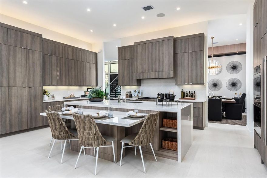 Magnificent Modern home featuring flat roof, floor to ceiling glass and extraordinary Ipey wood accents, 6 Bedrooms, 7 Full Baths, 1 half bath, a home office, loft, clubroom, with a 4-car privacy-glass garage doors. Chefs dream kitchen with everything you could possibly want! Modern kitchen layout with integrated appliances, upgraded custom Butler's Pantry and large walk-in Pantry with Double Cabinet Pantry. Dining Room has a gorgeous custom wall detail with lighting and seating for 12! There is a massive game room/home office with large wet bar great for entertaining.
12' Impact Glass Sliders in Family room, Living Room and Clubroom. 12' Impact Entry Door surrounded by impact glass wall and custom wall detail with lighting features from floor to ceiling. A floating staircase with glass railing or a custom elevator brings you upstairs. Elegant Master Suite with sitting area, leading out to the oversized covered veranda with glass railing overlooking the pool and lake. Master bedroom has morning bar and rotating TV wall. Large walk-in master closets with custom built in closet systems. Master bath package including a designer free-standing tub, oversized frameless shower with double entry, rain shower, double shower heads and body sprays, floating cabinets and glass enclosure water closets. Outside, a beautiful custom contemporary pool including a spa with raised sun deck awaits. Made for entertaining, a summer kitchen under a large covered patio overlooks a beautiful water view! Includes a gas grill and outdoor stainless-steel refrigerator. Marble Driveway with upgraded Landscape package and Front Entry water feature.