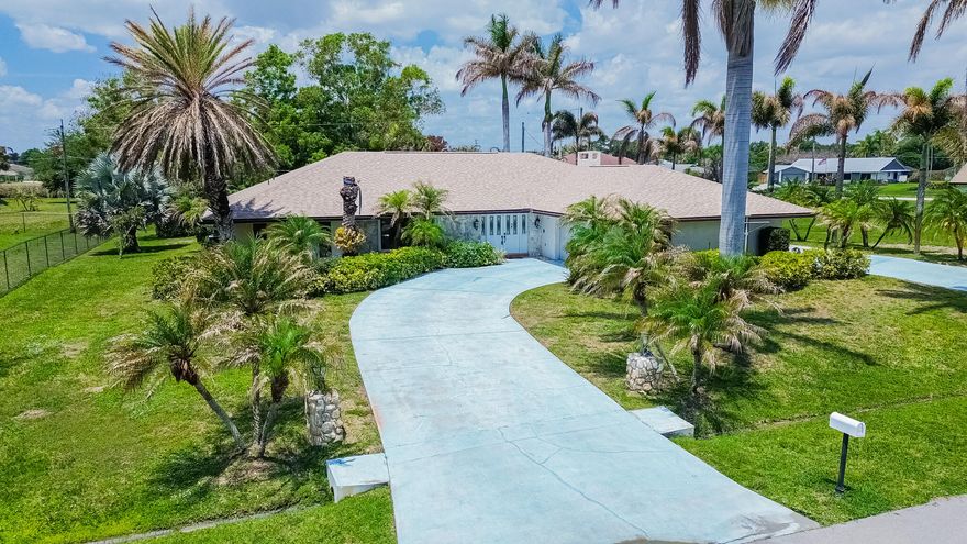 Tropical living awaits in desirable Sandpiper Bay! Situated on an oversized .45-acre lot with 33 palms, this spacious CBS pool home offers 3BR/2.5BA, a split floor plan, and a 2-car drive-through garage. Inside, enjoy oversized living areas, wood laminate flooring in the kitchen and family room, an updated kitchen with thick granite countertops & stainless steel appliances, plus a huge family room with fireplace. Step outside to a covered lanai with custom shiplap ceilings overlooking the screened heated pool & spa with new screening in 2024. Additional features include a 2025 roof, 2-zone A/C, 2 water heaters, city water & sewer, solid wood doors throughout, laundry room with sink, spa tub,  and storage shed. A perfect home for entertaining and enjoying the Florida lifestyle!