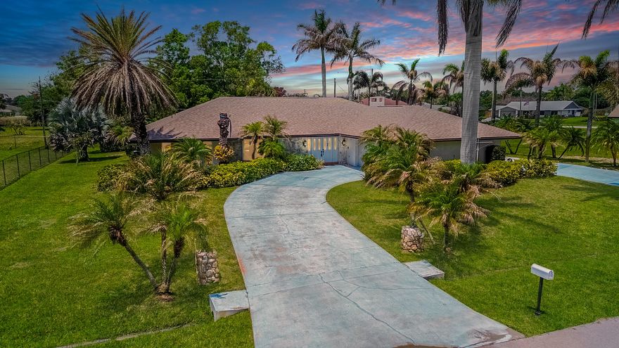 Tropical living awaits in desirable Sandpiper Bay! Situated on an oversized .45-acre lot with 33 palms, this spacious CBS pool home offers 3BR/2.5BA, a split floor plan, and a 2-car drive-through garage. Inside, enjoy oversized living areas, wood laminate flooring in the kitchen and family room, an updated kitchen with thick granite countertops & stainless steel appliances, plus a huge family room with fireplace. Step outside to a covered lanai with custom shiplap ceilings overlooking the screened heated pool & spa with new screening in 2024. Additional features include a 2025 roof, 2-zone A/C, 2 water heaters, city water & sewer, solid wood doors throughout, laundry room with sink, spa tub,  and storage shed. A perfect home for entertaining and enjoying the Florida lifestyle!
