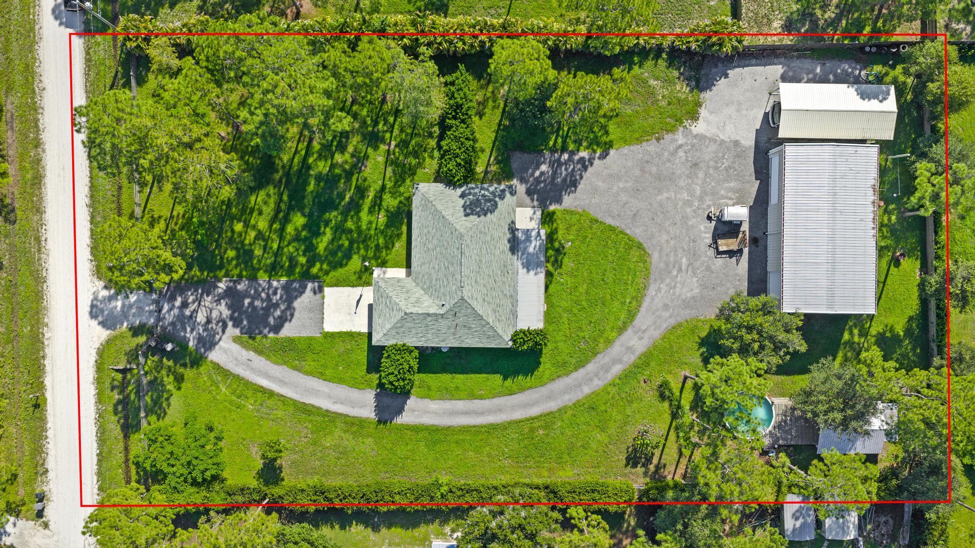 Discover the perfect blend of comfort, function, and country charm in this 3 bed, 2 bath Jupiter Farms home on a 1.25-acre fenced and gated lot. The split floor plan features a spacious primary suite with en suite bath and custom walk-in closet, while a newly renovated guest bath serves two additional bedrooms. Enjoy the oversized screened patio--ideal for entertaining or relaxing after a day outdoors. A massive 32x60 detached garage shop with three doors offers room for boats, RVs, or a workshop. Just beyond is a deck with a partially above-ground pool, outdoor dining area, toilet, and shower--creating a true backyard retreat. This home embodies Jupiter Farms living, offering privacy, space, and outdoor freedom just minutes from town conveniences, beaches, and top-rated schools.
