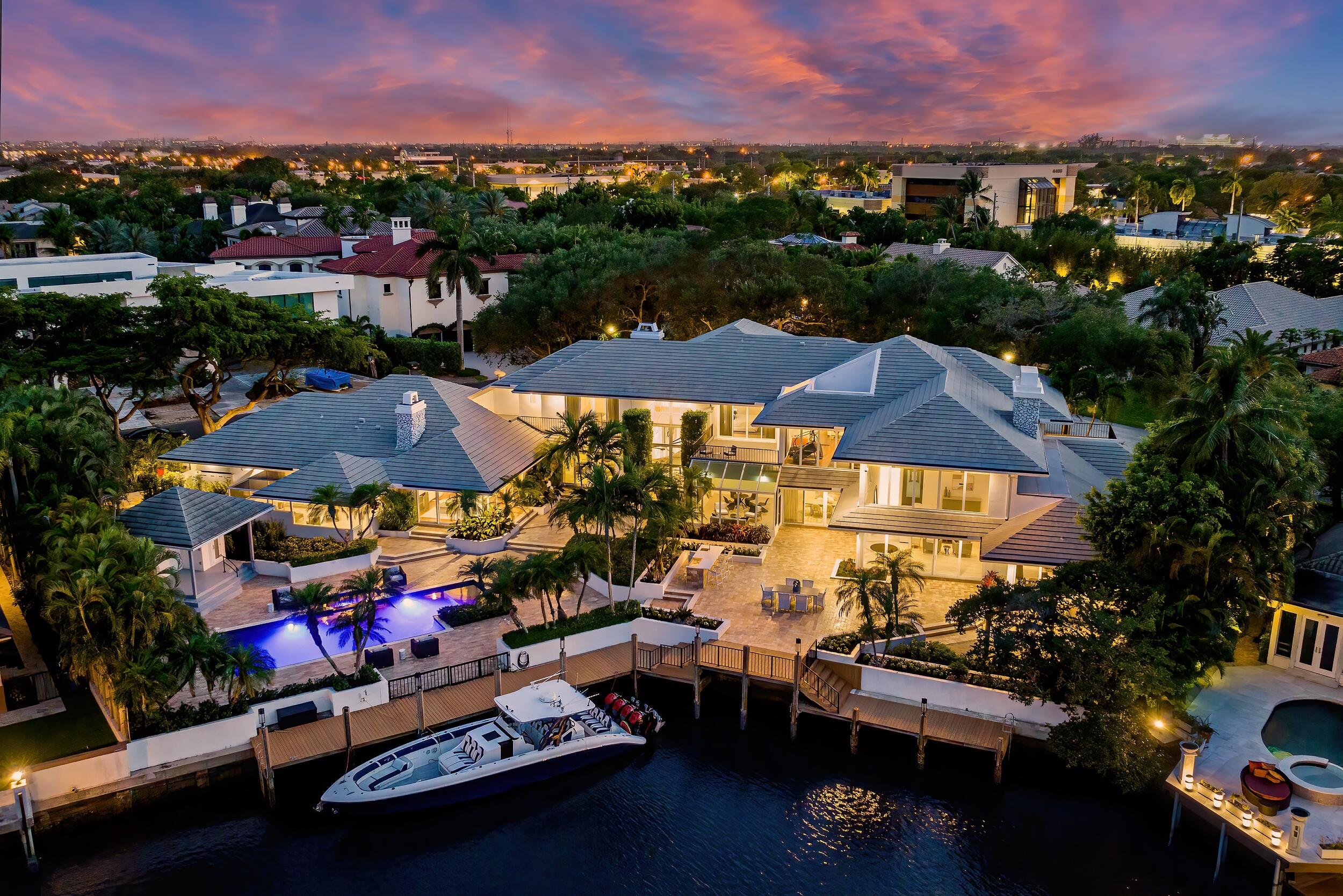 Extraordinary value in the most highly sought after gated waterfront community in East Boca Raton. The price has been adjusted for immediate sale. The Sanctuary, a private enclave in Boca Raton listed by Forbes as one of the most exclusive gated communities in the United States, provides an appropriate setting for this contemporary masterpiece sited on two prized waterfront lots. This 12,000-square-foot estate is cast in elegance, artful accents, and resort-style sophistication. A broad canopy of arching tree branches provides cover leading to a gated courtyard entrance. It's a thread of chic comfort and mesmerizing awe that extends throughout the five-bedroom layout (with 7 1/2 baths).