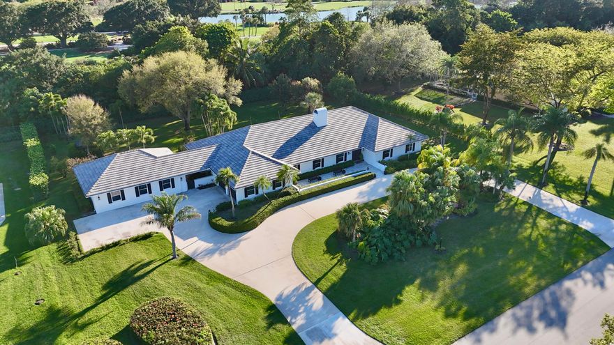 One-of-a-Kind Estate with Guest House in Prestigious Banyan Estates! Experience the best of South Florida living in this private 1.0101-acre retreat backing Banyan Golf Club. Located in a gated community of just 41 estate homes, Banyan Estates offers lake access for boating, kayaking, jet skiing, and fishing. The single-story main home features 5 bedrooms + office, 2.5 baths, skylights, a stunning coral fireplace, impact windows and French doors that open to a 41-ft covered patio with wet bar/BBQ—perfect for entertaining. Separate 1BR Guest House/ ADU with kitchen and laundry. Mature fruit trees, low HOA, tennis courts, and a prime location near Wellington, equestrian venues, PBIA, beaches, top -rated schools and South Florida Fairgrounds.  This estate is perfect for multi-generational living, entertainment, and making the most of South Florida life in one of Palm Beach County's most desirable communities.