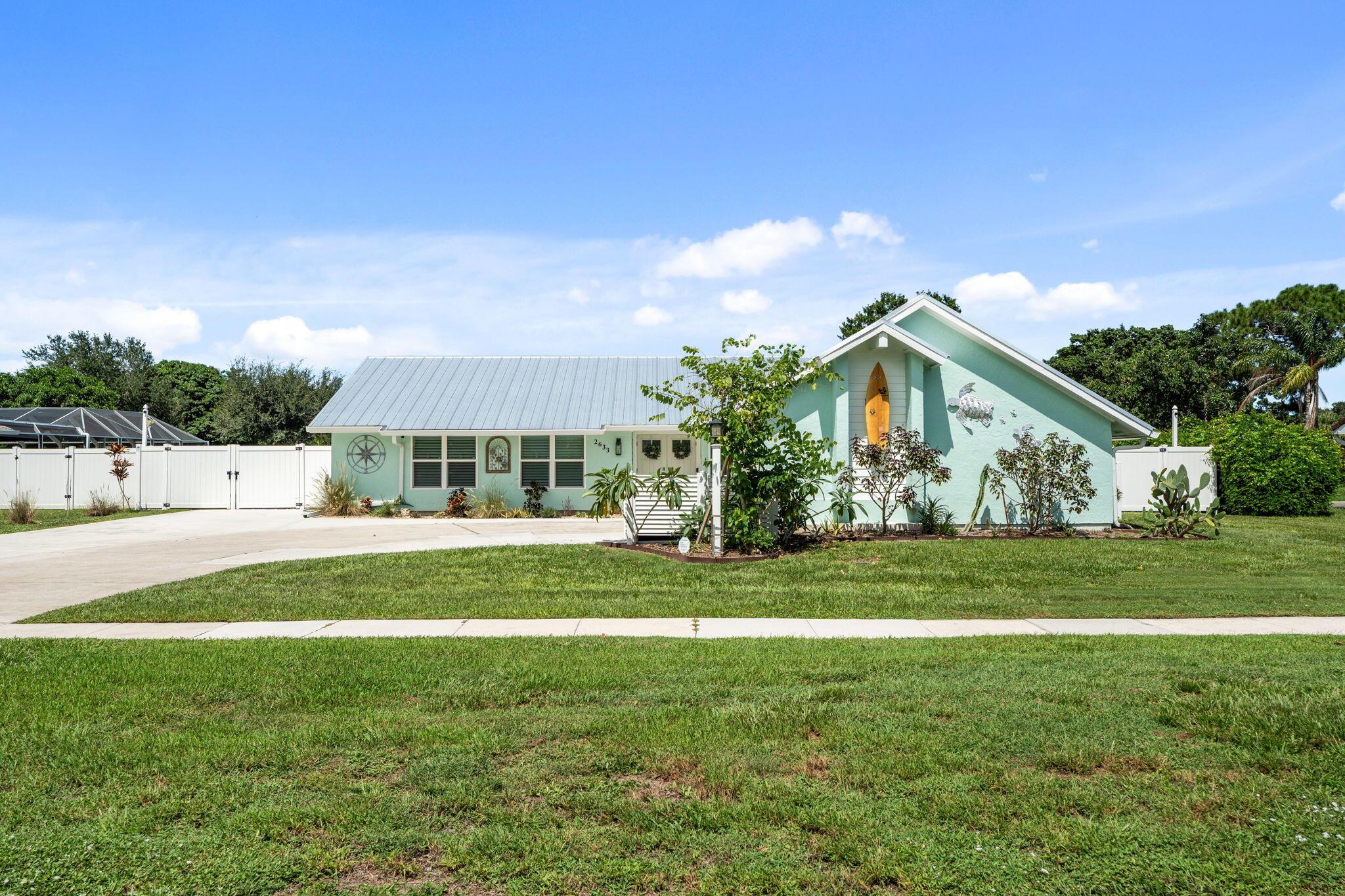Located in desirable Sandpiper Bay, this pristine 3 bedroom 2 bath home features an open floor plan, with kitchen/dining/living/office area. The perfect blend of modern comfort and Florida charm, it has been completely upgraded since 2019. Improvements include: metal roof, impact windows and doors, AC and Hot Water heater, security system with cameras, electric panel with 200 amp service; updated kitchen with granite tops, large center island and separate pantry. Shiplap accents throughout, updated bathrooms, all custom window treatments including plantation shutters, Roman shades and Avertes. Outside is your fully fenced backyard with canal view, large paver patio with 15x30 screened room, 12x24 workshop and a gravel parking area with ample room to store a boat, RV or classic car.