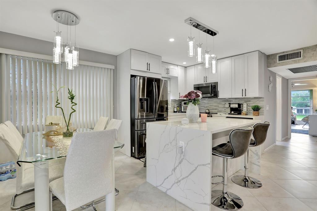 Stunning second-floor corner unit in the desirable 55+ Century Village community. This fully remodeled 2-bedroom, 1.5-bath condo boasts a beautiful lake view and a brand-new kitchen with quartz Calacatta island countertops, new appliances, and custom cabinets. Elegant tile flooring flows throughout. Additional upgrades include a new tankless water heater and central air conditioning (2020). Conveniently located near the Powerline entrance. Century Village offers resort-style amenities including a gym, theater, pools, clubhouse, pickleball, and more — even motorcycles are allowed.
