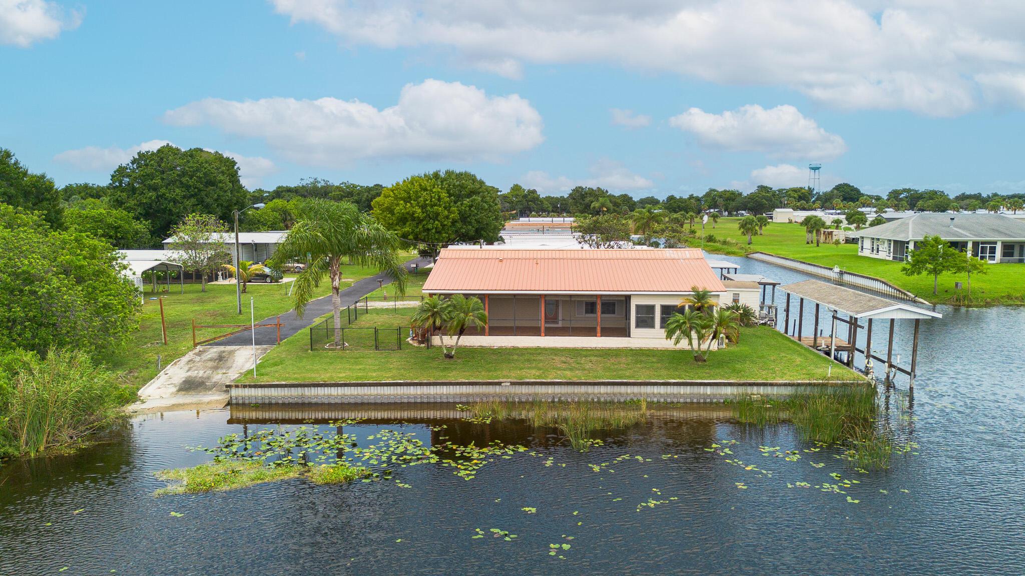Gorgeous waterfront 3/2 located on the serene rim canal. Relax in the Lanai off main bedroom while enjoying beautiful sunrises. The expansive covered screened porch is ideal for hosting gatherings or unwinding while you soak in captivating views of wildlife and serene water. This exquisite property boasts new vinyl flooring in the main bedroom, living room, kitchen, dining room and laundry room giving it a fresh and modern feel. For boating enthusiasts, the home features a boathouse w/lift and deck, perfect for all your water adventures.Additionally, you'll own 2 extra lots: a spacious storage shed w/a roll up door and access door and a covered garage. Nestled on a private street with exclusive access to a boat ramp owned by HOA members. HOA has a private doggie park! CHECK MORE INFO!!