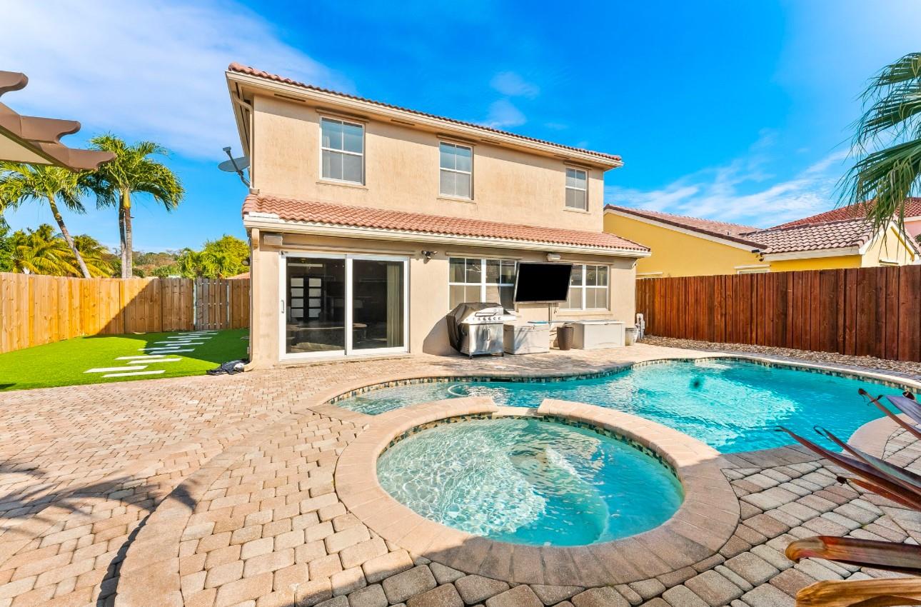 Welcome to your own tropical retreat! This beautiful 2-story home offers a private backyard oasis with a heated saltwater pool and elevated spa, covered lounge area with ceiling fan, and lush palm trees — perfect for relaxing or entertaining. Fully fenced yard includes an artificial turf side yard with modern stepping stones, great for pets and kids. Inside, enjoy an updated kitchen with granite counters, stainless steel appliances, and plenty of cabinet space. The open dining and spacious living area overlook the pool for seamless indoor-outdoor living. Highlights include a BBQ area, mounted outdoor TV, stylish wood-look floors, and inviting curb appeal with manicured landscaping and a 2-car garage. This home is move-in ready in a. Seller is willing to help cover some buyer concessions