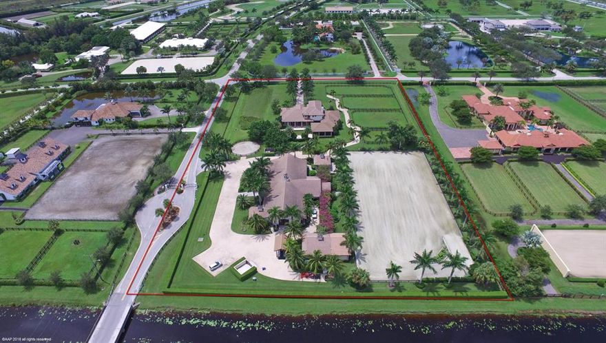 This exquisite Palm Beach Point property is an equestrian's dream! The main house has 6 bedrooms (+ office), 5 full + 2-1/2 baths and beautiful marble & hard wood floors, volume ceilings, French doors & crown molding throughout. The kitchen has stainless steel Thermador DOUBLE wall ovens, refrigerator & dishwasher and a GE stove & microwave. There is a double sided gas fireplace in the family room & media room, which overlooks out to the covered extremely large Summer kitchen. There is a beautiful outdoor bar with tongue & groove ceiling, granite counters, stainless steel double door refrigerator, wine cooler, ice maker, dishwasher, gas grill & a Big Green Egg. The covered patio has electric roll down screens looking out to the pool/patio area with a waterfall extending from the hot tub.