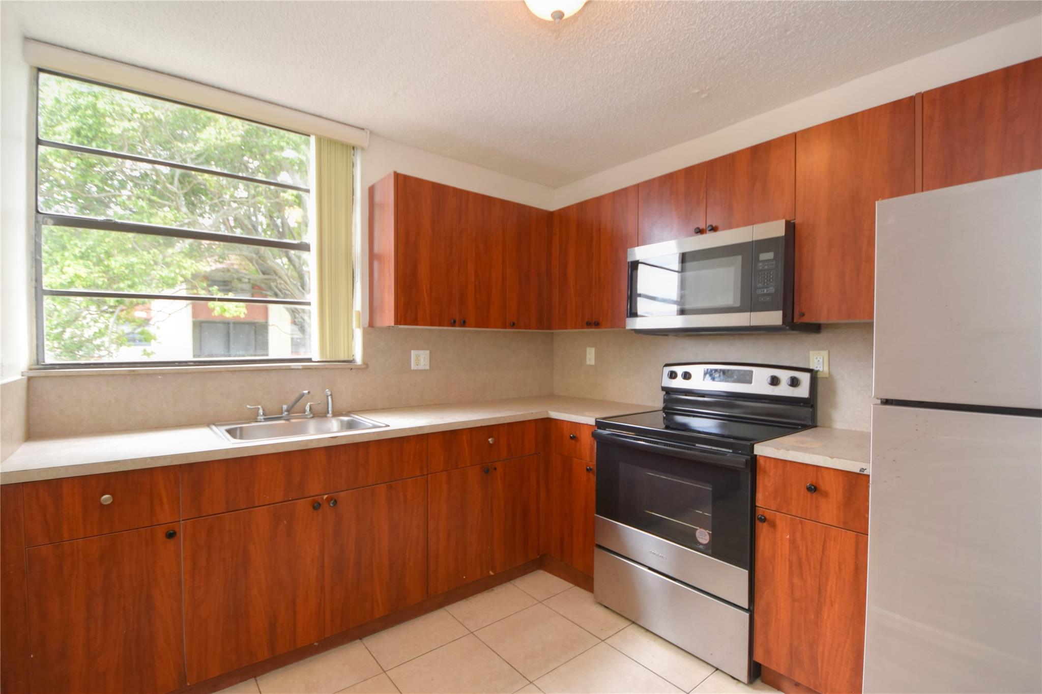 This large 3 bedroom, 2-1/2 bath condominium is centrally located near major roads, highways, shopping, dining, and lots of recreation. Windermere Center, Mission Lake Park, Lauderhill Aquatic Center, and the Boys & Girls Club are nearby. The unit has two stories with the kitchen, dining, living room, laundry, and half bathroom on the first floor, and the three bedrooms and two full bathrooms are on the second floor. Tile floors throughout. The balcony overlooks a park area. Large windows bring in lots of natural light. The association will soon be making repairs and improvements for the 40-year inspection which will transform the buildings and property.