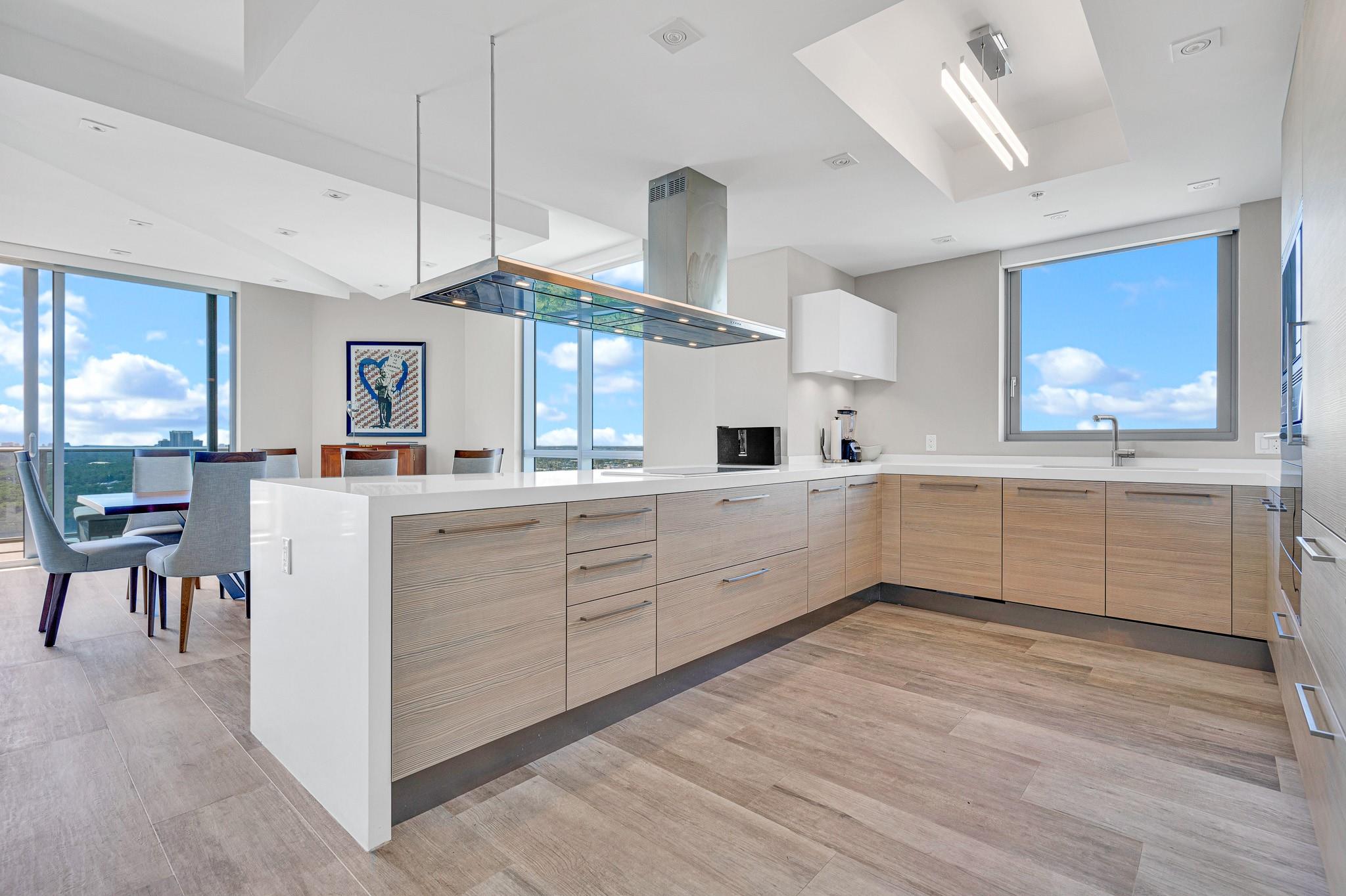 Impeccably furnished and professionally decorated corner unit at The Reserve at Marina Palms. This 2-bedroom, 2.5-bath residence with a converted den offers 1,958 sq ft of elegant living space. Enjoy stunning south and southwest bay and lake views from the expansive living area and oversized terrace. The open kitchen features high-end appliances and custom cabinetry. Architectural details, custom doors, and designer window treatments elevate the interior. The primary suite includes a sitting area, walk-in closet, and spa-inspired bath. Includes 1 assigned parking space and large storage. Luxury amenities include lagoon front pool, summer kitchen, fitness center, spa, playroom, and more.
