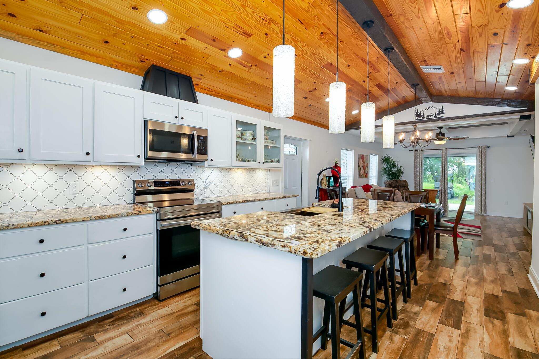 Enjoy carefree living by the Lake in Buckhead Ridge! Custom-Built in 2023, this 3BR, 2BA CBS home sits on a navigable canal just minutes by boat to world-class bass fishing in Lake Okeechobee. The bright kitchen invites you in with white cabinets, granite countertops, large kitchen island, and stainless steel appliances. Luxury touches include wood-look tile floors, tongue & groove ceilings, and custom built-in shelving. The spacious master suite offers a walk-in closet, private outdoor entrance, walk in shower, and dual vanities. Relax on your extended covered patio or tinker in your two hurricane-rated sheds--one for grilling, the other a fully air-conditioned workshop! Impact windows & doors complete this move-in ready home perfect for year-round or seasonal Florida living.