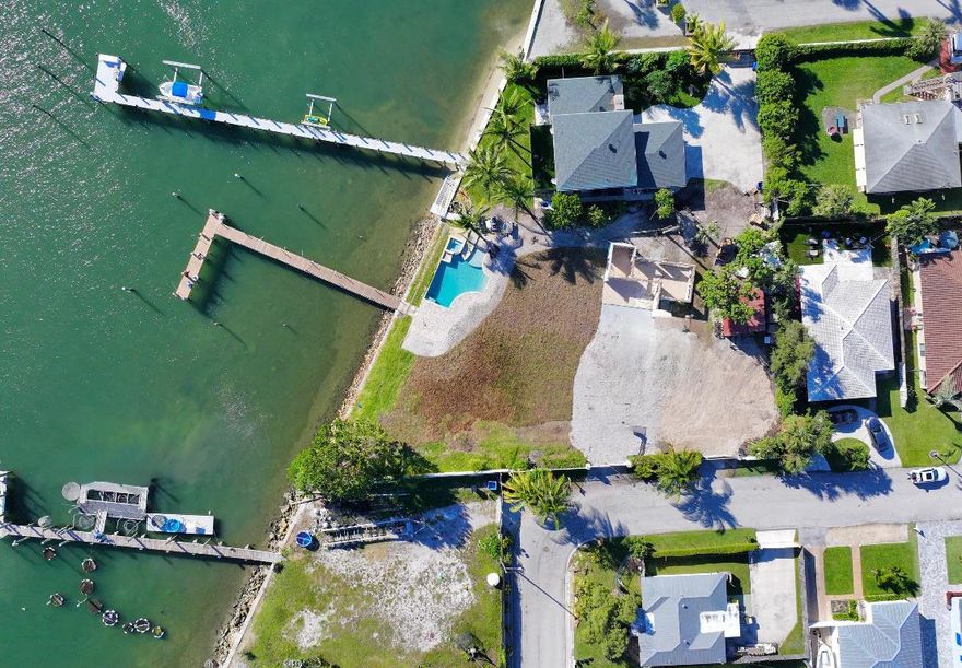 The outdoor grill with a large island makes hosting gatherings a breeze, while the dock space provides the perfect spot to park your boat. Don't miss out on this incredible opportunity to build your dream waterfront home with beach access! Start living your waterfront dream today!"