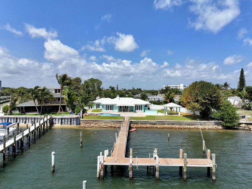 Rare opportunity to own a waterfront paradise with your very own dock space! This exquisite home is ideally situated across from Peanut Island with direct Intracoastal access, allowing you to bring your boat and enjoy easy access to the ocean in just minutes.In addition to the main house featuring 3 bedrooms and 3 bathrooms, and a charming 2-bedroom, 1-bathroom guest house, this property offers the unique opportunity to build two single-family homes on the 0.46-acre waterfront lot. Perfect for families, investors, or those who love to entertain, this property boasts a stunning pool overlooking the Intracoastal, set on a spacious lot with a sprawling backyard and inviting cabana sitting area.