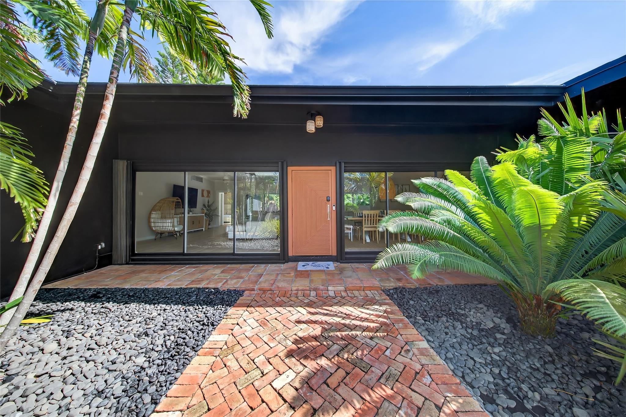 Perched on a ridge and surrounded by lush tropical greenery, this stylish 4 bed, 3 bath Mid-Century Modern pool home sits in the desirable Harbour Inlet—just a short walk to Fort Lauderdale’s best beach! Designed for indoor-outdoor living, the home features floor-to-ceiling glass with panoramic views of the new heated pool, marble paver patio, and professionally manicured grounds! The bright, open layout includes multiple seating areas, vaulted ceilings, a central kitchen w/ pass-through to the pool area, and two spacious primary suites on opposite sides—perfect for privacy or guests. Outdoors, enjoy privacy via lush hedges & fencing, generous patio space, and storage sheds. Whether full-time living or a vacation escape, this home offers the ideal blend of style, comfort, and location!