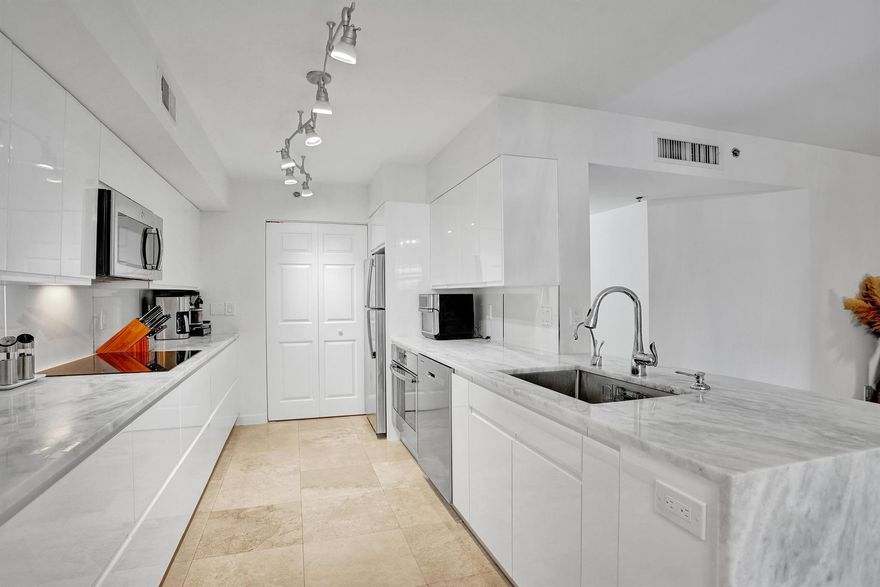 Completely renovated 1st floor corner unit with full impact glass windows and doors in gated community with pool/tennis/pickleball. Can lease right away. No expense spared in this beautiful condo w/ marble floors leading into a stunning modern kitchen with sleek custom high-end cabinetry, quartzite countertops with a waterfall edge, and stainless steel appliances. Bathrooms are tastefully updated with matching quartzite countertops and dual sinks in the primary suite. A bonus space off the living room is currently used as an office. Additional highlights include a covered patio off both the primary bedroom and living room, spacious bedrooms, walk-in custom closets, full-size in-unit laundry, and a newer AC. Can be rented immediately! ideal for both end users and investors. Community info: