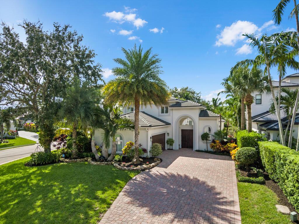 Welcome to your home in Water's Edge Estates. Nestled on a cul-de-sac in this 20 homesite gated Intracoastal community, this 4 bedroom 3 full bath home offers a ground floor master suite overlooking the courtyard pool/patio. It features an open floor plan, coffered ceiling, custom kitchen with a 6-burner gas Wolf range, stainless appliances, a wine bar and quartz countertops. Wood floors complement the living space throughout the home. Impact windows and doors let in the beautiful sunshine for a light and bright home. The large corner property offers plenty of back yard to further your outdoor experience and all in a very private setting. The pool area offers a saltwater pool with waterfall, a built-in summer Kitchen creating the perfect setting for poolside entertaining. The spacious