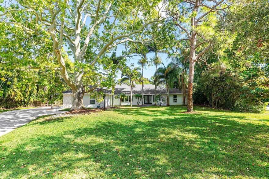 MUST SEE! Discover the charm of Imperial Woods, a hidden gem nestled in one of Jupiter's most sought-after neighborhoods. This fully renovated 4-bedroom plus large bonus room, 3-bath pool home offers nearly 3,000 sq. ft. of pristine living space ~ all on one level for easy South Florida living. Set on over an acre, this property is surrounded by lush landscaping and a fully fenced yard, creating a private oasis ideal for relaxing or entertaining. Enjoy peace of mind with complete impact windows and doors, plus a newer roof and stucco siding (2017). Inside, natural light fills the open floor plan, where spacious living areas feature luxury wood-look tile flooring and soaring ceilings.