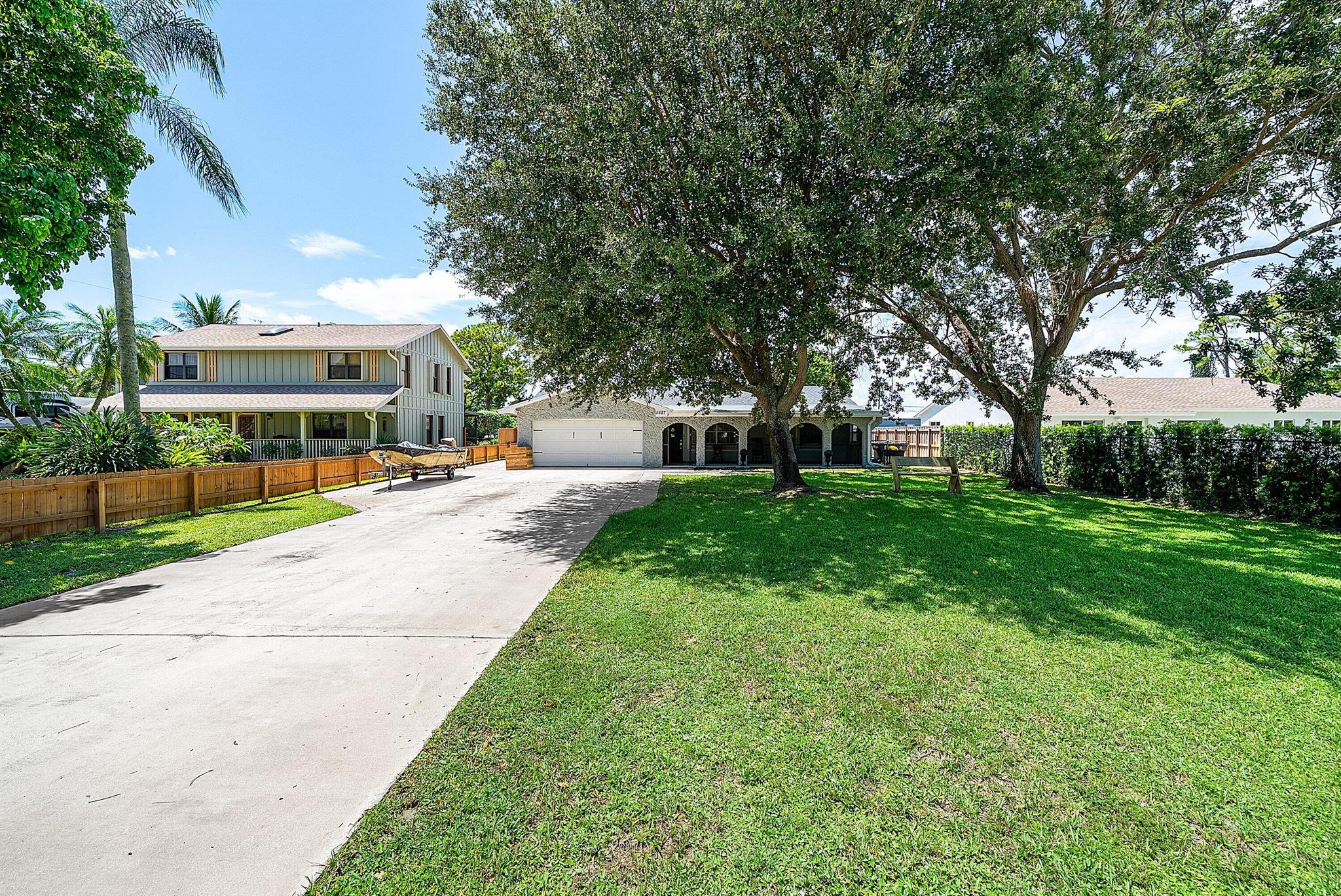 Discover the perfect blend of charm and modern living on a 1/2 acre in Palm Beach County. This remodeled 3BR/2BA modern farmhouse offers new luxury vinyl plank (LVP) flooring, remodeled kitchen & bathroom, recessed lighting, solid-core doors, and a walk-in pantry. A separate office space adds flexibility. Outdoors, enjoy a resurfaced pool with child safety gate, rocking-chair front porch, fruit trees, chicken coop, and a 220 sq ft permitted shed. Practical upgrades include a nearly-new roof, accordion shutters, new appliances, and an electric gate for the fully fenced yard. With no HOA, bring your RVs, golf carts and boats, or even build a guest house. All just minutes from shopping, dining, and everything Palm Beach has to offer!