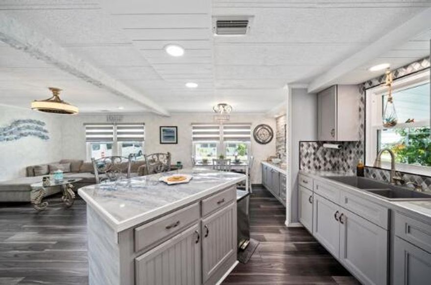 FULLY REMODELED & MINI GREEN for PETS at this 2 bed/2 bathroom beauty where SAFETY FEATURES merge w/ SOPHISTICATION. Don't miss this home which outshines the rest! BUILT FOR STRENGTH &SOPHISTICATION. LIST OF NEW Items includes but not limited to:DOUBLE HUNG, IMPACT WINDOWS w/ CUSTOM SHADES, SUBFLOORING w/ LUXURY VINYL PLANK FLOORS, DRYWALL, ENTIRE KITCHEN, APPLIANCES, ENTIRE MASTERBATH, Pantry w/ PULL-OUT drawers, CUSTOM DOORS, HAND CRAFTED STONE MIRROR. Fully enclosed Florida Rm doubles as den/extra bedroom/home office. AC 2020. ROOF Painted & SEALED 2024. Fireplace & 60''TV STAY. Stone Patio perfect for lounging/hosting & Grass area perfect for PUPS! Active 55 + community - Lot Lease of 765 incl trash, Clubhouse, fitness, game room, pool, hot tub, library, billiards & more!