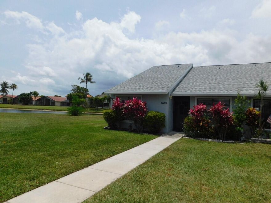This beautifully maintained 2 bedroom, 2 bathroom villa offers serene lake views, abundant natural light, and an airy feel enhanced by vaulted ceilings. The updated kitchen features modern cabinetry and granite countertops, while both bathrooms include updated vanities with matching granite, creating a cohesive, elevated look throughout. Large windows and soaring ceilings fill the living spaces with natural light, making the home feel warm and inviting. Step outside to the screened in patio overlooking the tranquil lake — the perfect spot to relax, dine, or enjoy the peaceful surroundings. Located in a quiet, well kept community, residents enjoy access to a variety of amenities including a clubhouse, pool, bocce ball court, shuffleboard, and tennis courts.  The villa also includes two dedicated parking spots, adding convenience to everyday living. Move in ready and thoughtfully updated, this home blends modern touches with a calm, scenic setting and a vibrant community lifestyle.