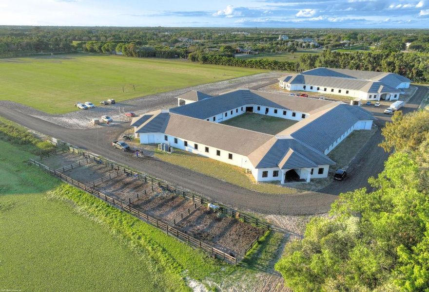 Reduced $7,500,000. One-of-a-kind opportunity to own a 46.96 acre equestrian facility in a prime Wellington location on a paved road and with no homeowner's association. The property boasts 4 stables, totaling175 stalls, full size polo field with exercise track, a second stick & ball practice field, maintenance garage and two staff houses. Two new show barns were built in 2024, one with 52 stalls & the other with 59, it also features a 2nd floor viewing room with balcony overlooking the polo fields. The original courtyard-barn holds 48 horses and the over flow barn has 16 stalls.  The staff houses each have 4BR & 4Bths.  The property is comprised of multiple parcels which could lend itself to future subdivision. This farm has unlimited potential for all equestrian disciplines. A must see!