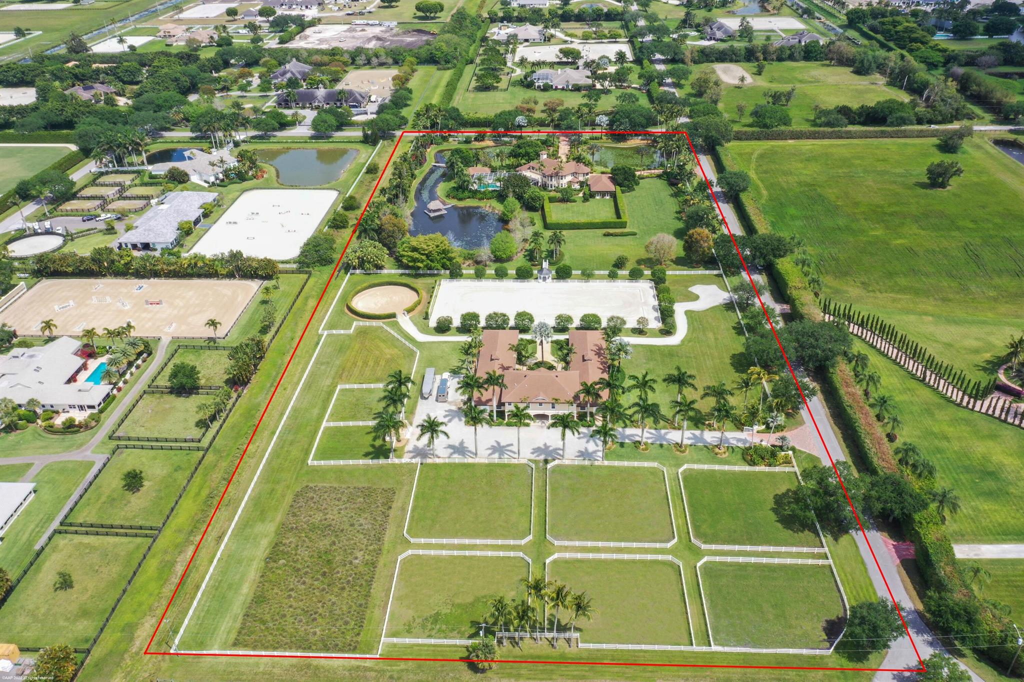 Private estate situated on 10.83 acres in the heart of Wellington's premier gated equestrian subdivision of Palm Beach Point. The main residence has 4Br all w/ in-suite baths, plus a pool-side cabana suite w/full bath. The home also boasts stone floors, center-island kitchen w/gas cooking, a spacious master suite with his & her offices & a home gym. The riders in the family will love the beautifully landscaped 12-stall courtyard barn w/ 4 wash stalls, lounge, feed & tack rooms. There are 8 generous sized grass paddocks, round pen & 230' x 100' arena w/ world class footing lined by beautiful shade trees & viewing gazebo. The property lends itself to a covered arena and/or a grass grand prix field w/ the ability to have up to 24 stalls. Possibly the best deal on 10+ acres in Wellington!