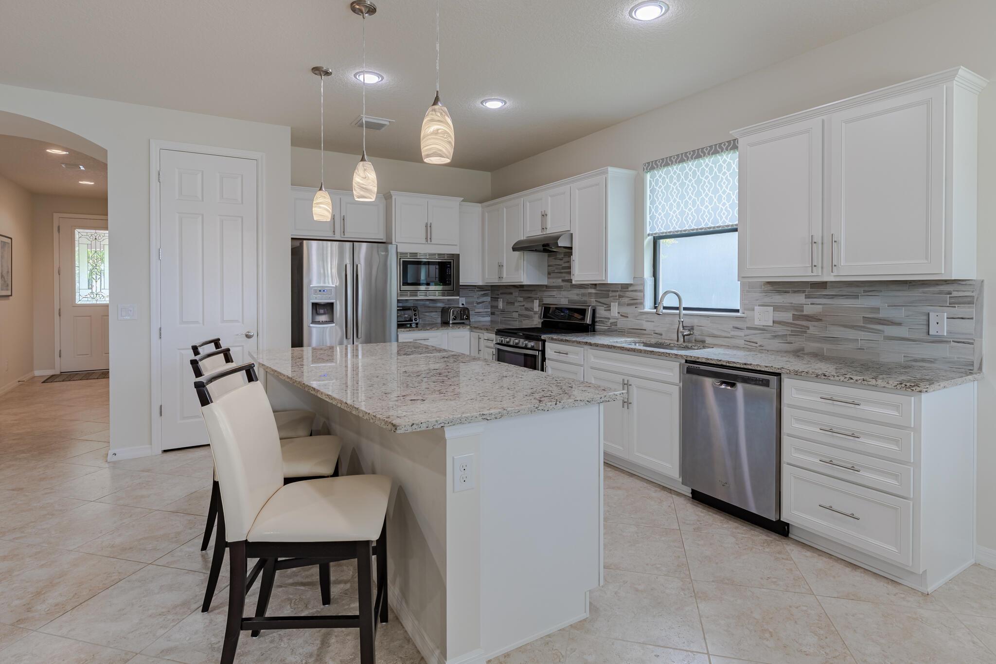 Welcome to this meticulously maintained home offering 2 bedrooms, 2 bathrooms, plus a versatile den/office with French doors. The gourmet kitchen features a large island, GAS range w/hood, SS appliances, stylish backsplash, and designer lighting. The open-concept layout seamlessly connects the kitchen, dining, and living areas. Gorgeous tile flooring throughout. A spacious dining or sunroom leads to the extended screened lanai, where you'll enjoy sparkling lake views and golden sunsets. Master suite is a true retreat with spa-like bath with walk-in shower, dual sinks, walk-in closet w/built-in shelving. Additional highlights: laundry room w/storage, 10' ceilings, plantation shutters, remote blinds, 8-ft doors, ceiling fans, smooth-finish walls and IMPACT windows. New A/C and water heater!