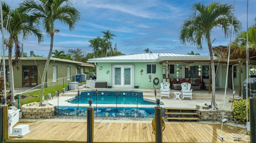 Ocean Access 3bed/2bath/pool on secluded cul de sac. Brand new metal roof, gutters, and 2 ton A/C. Hurricane Accordian Shutters/panels. Enclosed carport with garage door for golf carts, motorcycles, storage and house access. 35' Dock has pilings/bumpers, whips, lighting, electrical and dock box, fits approx 26'boat. 12' bridge clearance MHW. Updated Master bedroom with etched doors to patio, and bath with oversized shower. Updated custom kitchen solid oak cabinets, with SS appliances, double oven, dishwasher, 48" 6 burner gas cook top with exhaust hood and granite counters. Spacious laundry room with 2nd refrigerator. 2 spare bedrooms have carpet, balance tile flooring. Large sliding doors to travertine tile covered and fenced patio to pool with waterfall,AquaCal heater/chiller.