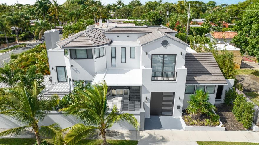Spectacular newly custom-rebuilt modern estate home encircled by a grandfathered-in, 6-foot tall concrete privacy wall on a corner lot in the quiet Flamingo Park Historical District of the City of West Palm Beach. Patio Outdoor Kitchen w/ Gazebo. Salt Water Heated Jacuzzi & Swimming Pool w/ Sun Shelf & In-Pool Chaise Loungers & Fountain Geysers. Gourmet VIKING Eat-In Kitchen & large Center Island w/ Water-Fall Edged Quartzite Countertops. Optional capsule elevator to second floor Master Suite w/ huge ensuite Master Bath w/ Safari Double Massaging Shower & Handcrafted Copper & Chrome Free-Standing Crystal Double-Slipper Jetted Tub. Two Walk-In's in Master Bedroom. Reflective Infinity Ceilings, 10' wide floor-to-ceiling wood-burning fireplace, wireless powered silhouette shades thru out.