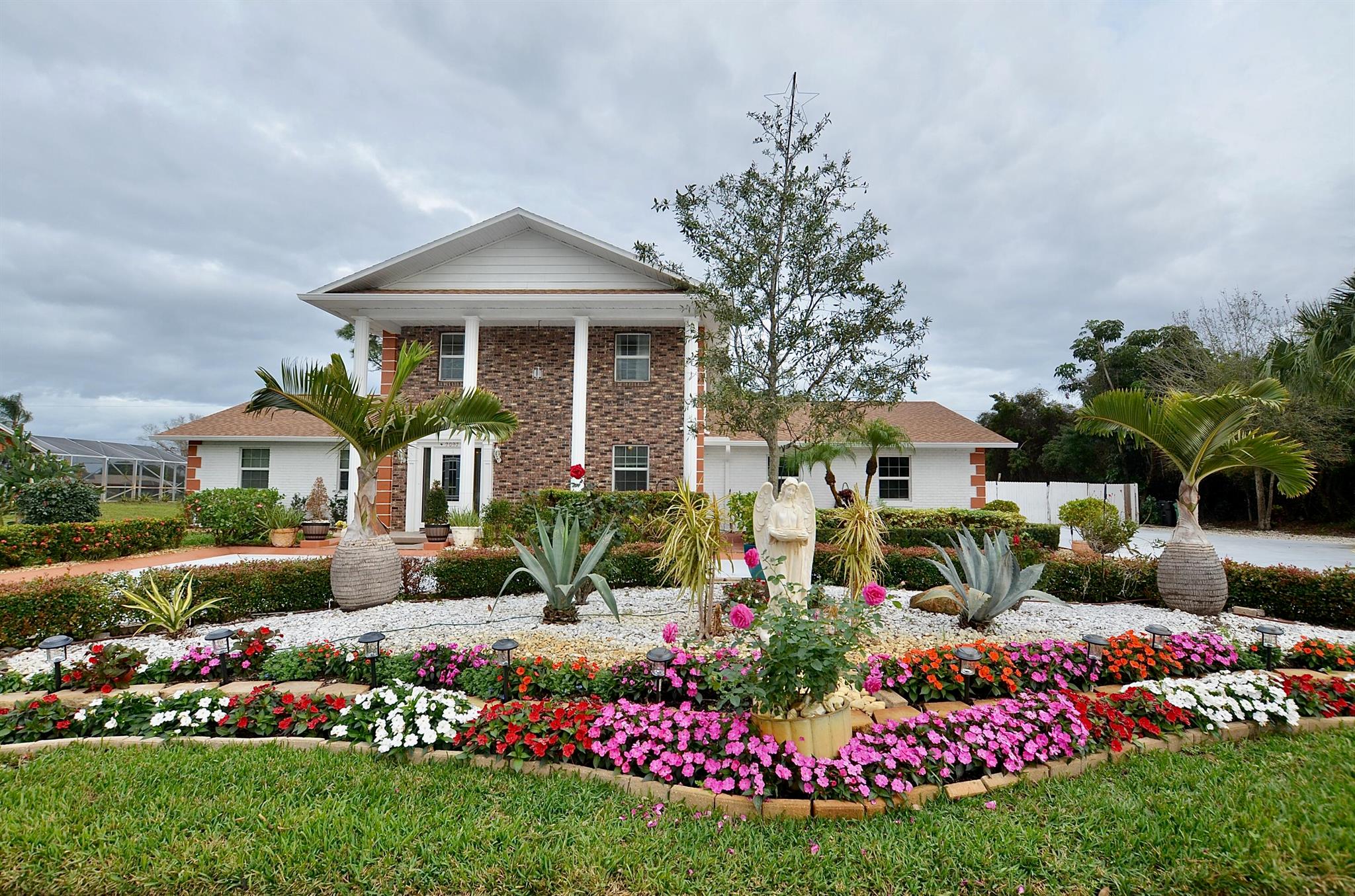 Majestic Southern Colonial Estate with Modern UpgradesStep into timeless elegance with this Southern Colonial-style estate, beautifully set on an expansive lot. Its iconic symmetrical facade, grand white columns, and brick-accented exterior exude classic charm while integrating modern updates for today's lifestyle.Recent upgrades include a brand-new roof (2023) and a new A/C system (2022), ensuring comfort and efficiency. The property is enclosed by a vinyl fence, providing privacy while maintaining its stately curb appeal.Inside, this 4-bedroom, 3-bathroom home with 3 garages offers generous space and refined finishes. The welcoming foyer opens to a grand staircase and a spacious living room with gleaming wood floors.