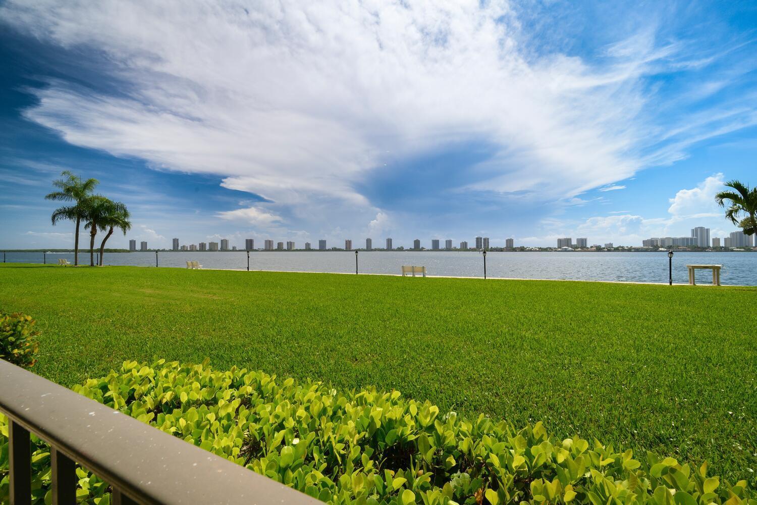 Imagine stepping into a serene waterfront condo where you're greeted by sweeping views of our glistening intracoastal that instantly sets a resort-like tone for everyday living. Wall to wall sliding doors and generously sized windows with a spacious patio frame these vistas, providing both relaxation and natural light. The building boasts two inviting swimming pools, one of which is heated, surrounded by sun loungers and cabana style shaded canopies. It's the perfect setting whether you're diving in for morning fitness or unwinding in the sun with a good book. Want a bit of playful competition? A dedicated putting green, pool table or life-size shuffleboard right on the grounds encourage casual practice and friendly challenges, giving the community resort feel. Coming into the condo, you