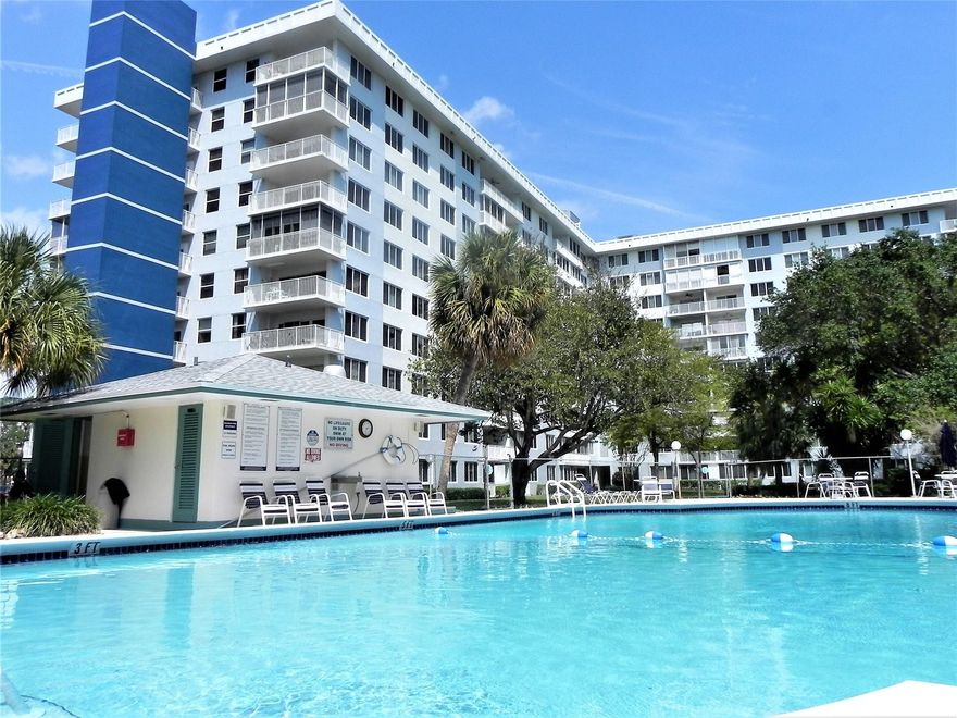 All ages welcome! Bright, beautifully updated deluxe corner 2/2 with an open layout, wide-plank flooring, fresh paint, and oversized impact windows for great natural light. The renovated kitchen features white cabinetry, granite countertops, stainless steel appliances, and a breakfast bar. Enjoy resort-style living with a large pool and lush tropical grounds. Relax on your private balcony overlooking greenery and the sparkling pool. Convenient assigned parking close to the entrance. Amenities include heated pool, walking trails behind building, clubhouse with kitchen, outdoor BBQ and bar area. Tennis and pickleball memberships available. Minutes from downtown nightlife, restaurants, shopping and Hollywood Beach. No pets, ESA animals only. Easy to show - see broker remarks.