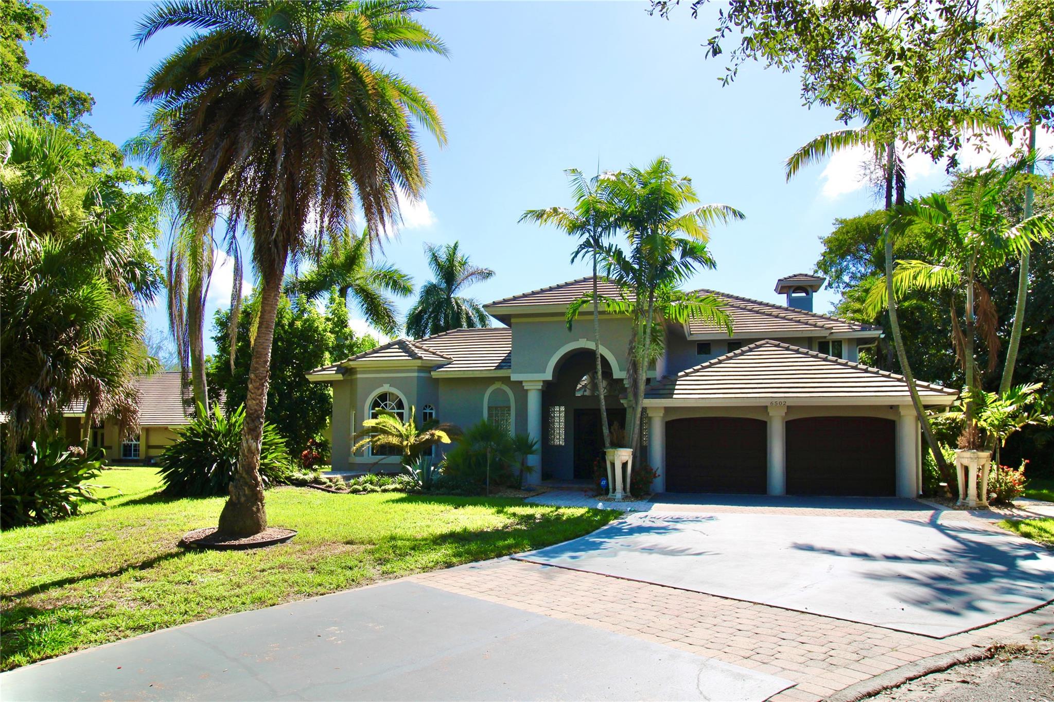 Discover this sophisticated 4,249-square-foot residence offering refined living on nearly an acre of lush, fruit-bearing grounds. Beyond its welcoming entrance lies a serene courtyard pool, an exquisite centerpiece for both intimate family moments and elegant gatherings. The thoughtfully designed split floor plan ensures complete privacy, with the master suite occupying its own wing, while guest accommodations rest on the opposite side. A separate poolside suite, connected under one roof yet privately set apart, enjoys captivating views of the sparkling water from across the master’s retreat. With its expansive grounds, this property offers the rare balance of luxurious indoor comfort and the freedom of open-air living—perfect for those who desire both sanctuary and sophistication.