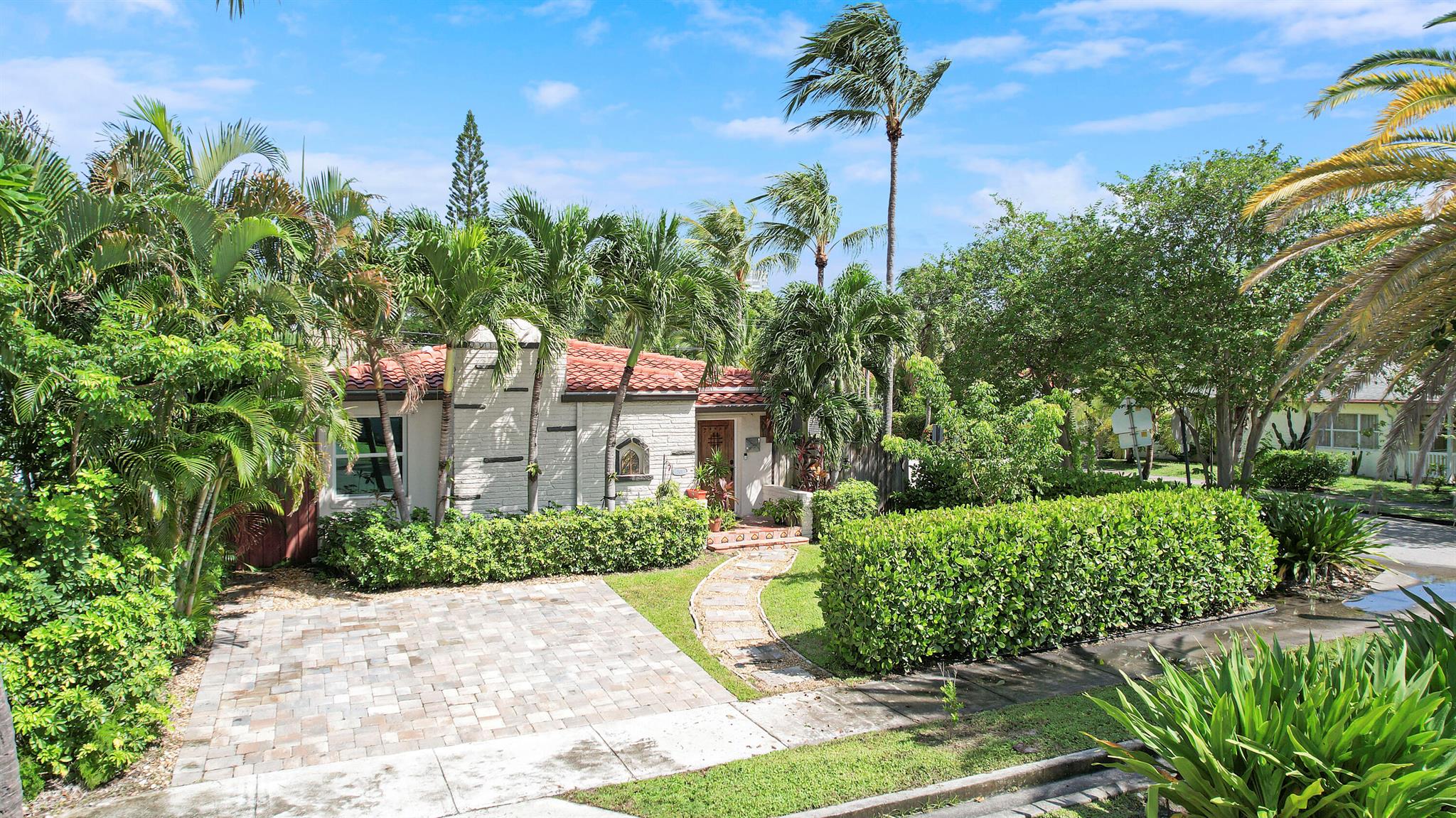 Welcome home to this lushly landscaped, Spanish-style gem in the desirable, no-HOA Northwood neighborhood. Built in 1946, it blends timeless charm with thoughtful modern upgrades. A fully fenced backyard oasis awaits-- saltwater pool, expansive pergola, and plenty of privacy for relaxing or entertaining. Step through the classic wood front door to an open, inviting layout featuring a custom bar with mini-fridge, a fireplace accented by a custom wood feature wall, and an open kitchen with quartz countertops, a large eat-at bar, and stainless-steel appliances. Bedrooms are generously sized; the guest bath is fully renovated. The primary suite offers sliding doors to the pool and an ensuite with an exterior door--ideal for post-swim showers.
