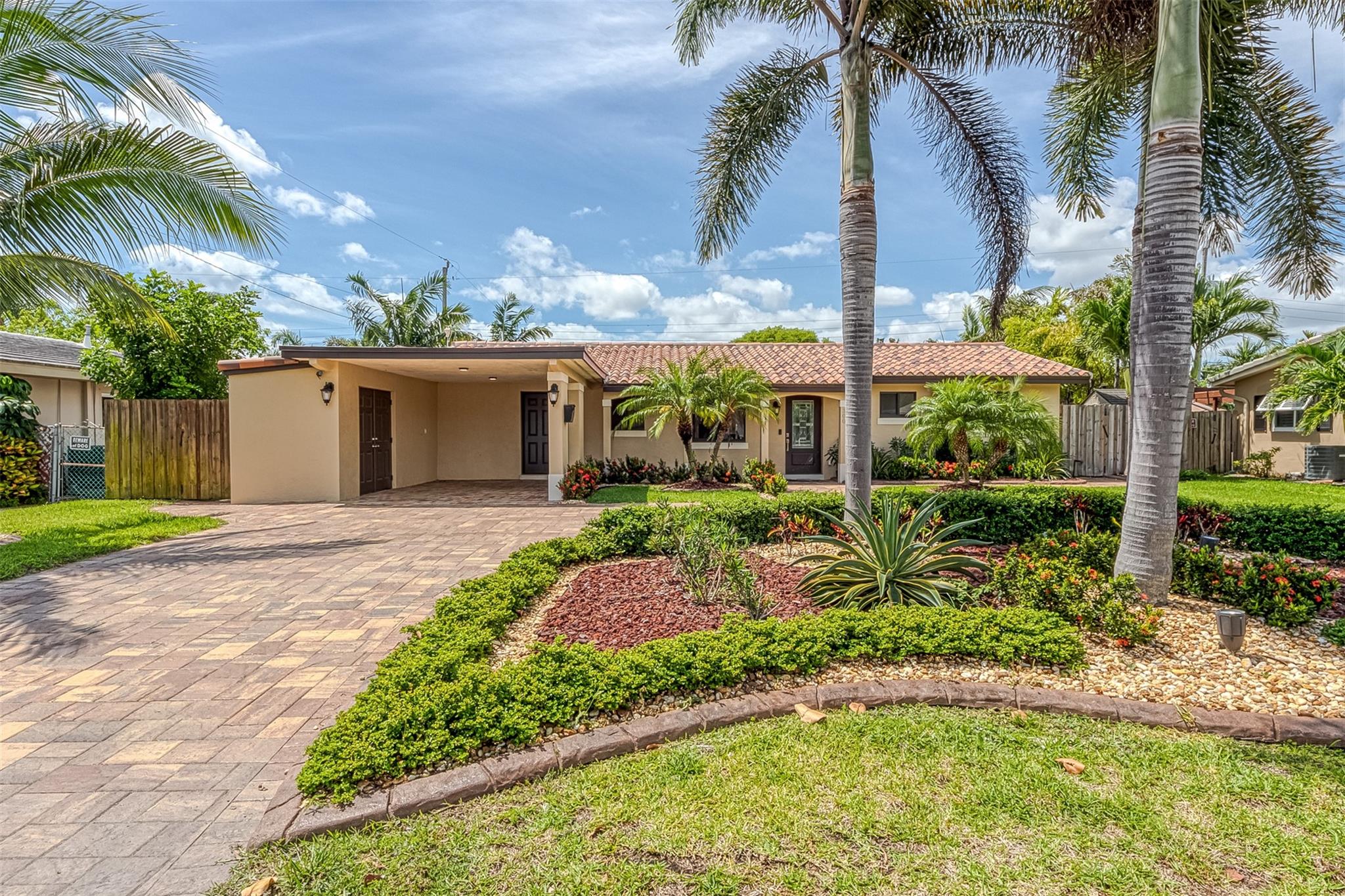 Beautifully remodeled home with no expense spared! From the new roof to impact windows, this beautiful pool home has it all! From the moment you pull up you are greeted by the large circular, pavered driveway with inviting front porch. Once inside you notice the impeccable attention to detail from the marble floors, crown molding & recessed lighting. The kitchen is a true cooks dream. It features an 11 foot center cooking island, bar seating, stainless appliances, wine fridge, breakfast bar & more. Enjoy cooking with great views of the pool & open flow to the rest of the house. The bedrooms are large and have great closet storage & both bathrooms are perfectly updated. Enjoy your backyard tropical oasis w/ 2 pergolas, professional landscaping, lighting, built-in bar & more!