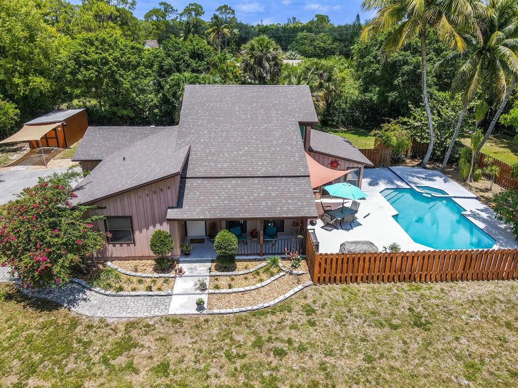 Gorgeous 3 bedroom, 2 bathroom with large FL Room overlooking the pool. This home features a lovely split level floor plan with the master bedroom on the entire second floor with a balcony overlooking the large 1.15 acre yard. The upgraded kitchen with brand new quartz countertops has plenty of storage and large island to entertain. The vaulted ceilings in the living room make a dramatic impact in the living space. This home is absolutely sensational for entertaining guests or just having the privacy of your own little getaway. Roof replaced in 2021, Security camera, solar powered driveway gate, new water system, 2 car garage and laundry, Impact windows on second level, Impact garage door, pool equipment updated. new shed, built in BBQ area.