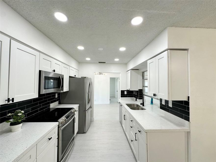 HUGE CORENER LOT! Large floor plan nearly 1,650 sq ft. 55+ community – Welcome to Mainlands of Tamarac! BIG backyard and what a peaceful garden view! New roof 2023. Very spacious 2/2 with room to add a 3rd bedroom if you want to convert the Florida room to a bedroom. The existing 2 bedrooms are NOT small! The bedrooms are on opposite sides of the home. Beautiful paver driveway with room for 3 cars plus a 1 car garage. Recessed LED lighting in all living areas & kitchen, quartz countertops, newer stainless appliances, 100% waterproof vinyl plank flooring, updated GE electrical panel, newer water heater, the list goes on. Each bedroom has a nice sized closet. Master bedroom has a large walk-in closet with built in storage. Master bathroom is equipped with a walk-in shower and private toilet.